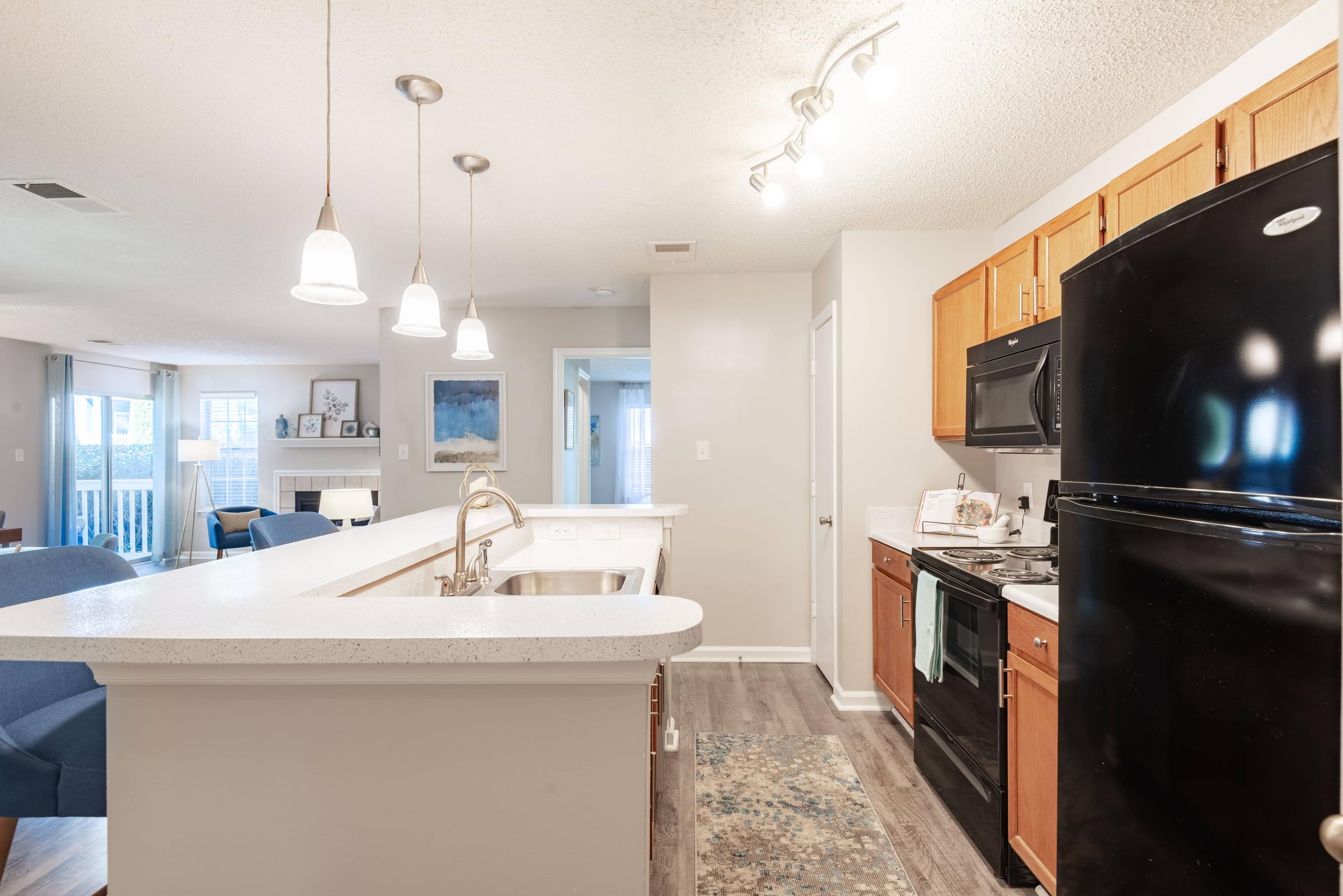 a kitchen with black appliances and white countertops