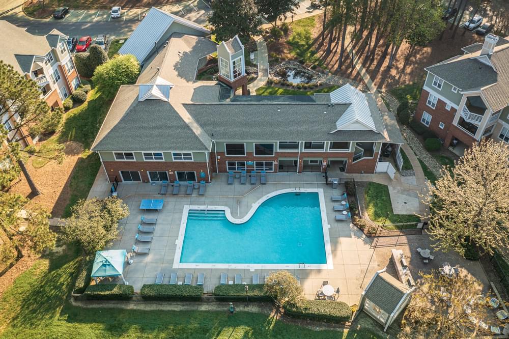 an aerial view of a swimming pool in front of a house