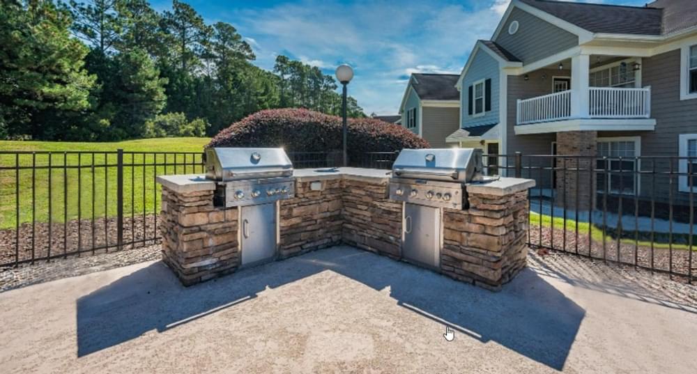 a backyard with two barbecue grills in front of a house