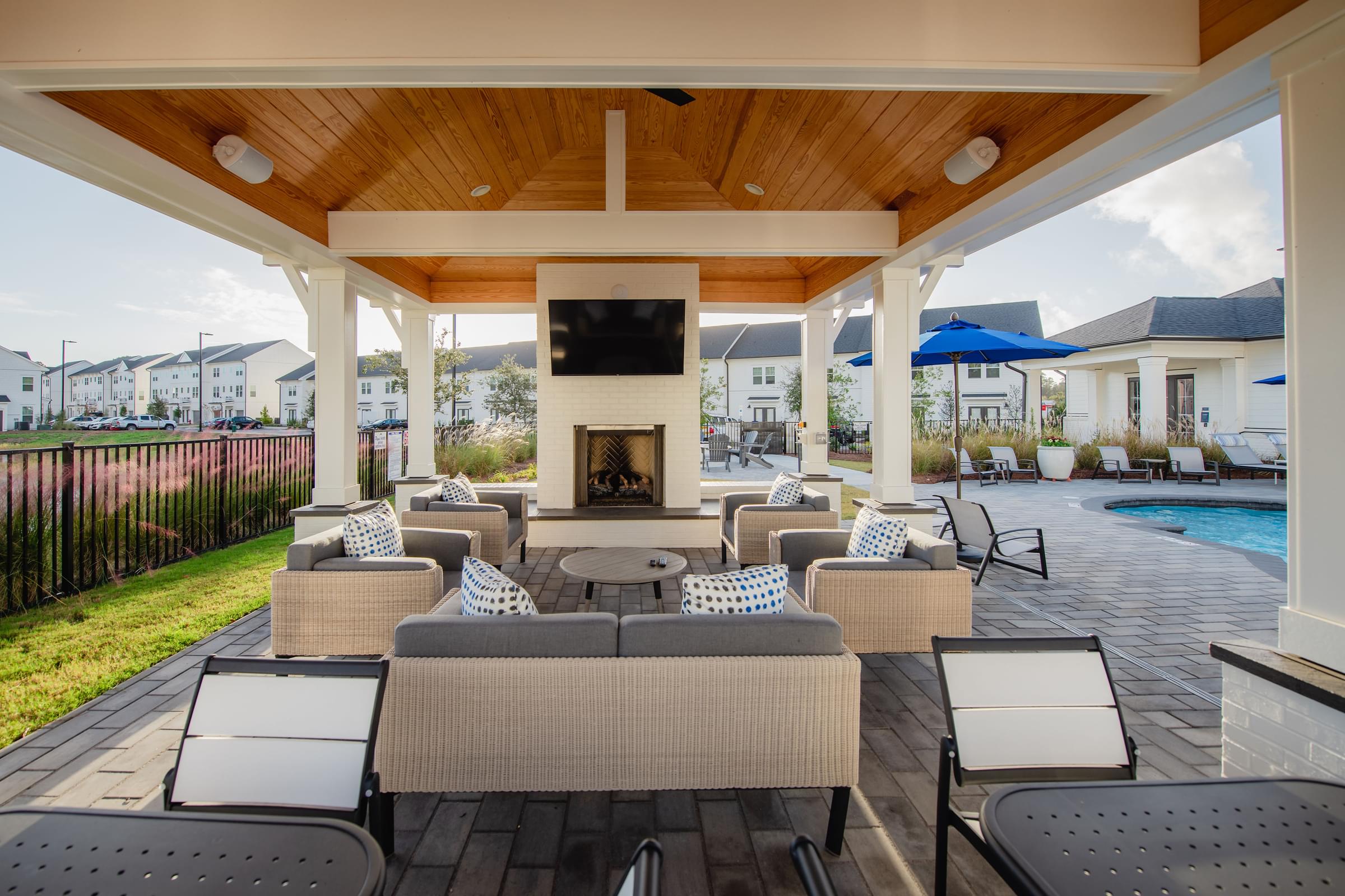 a covered patio with wicker furniture and a fireplace