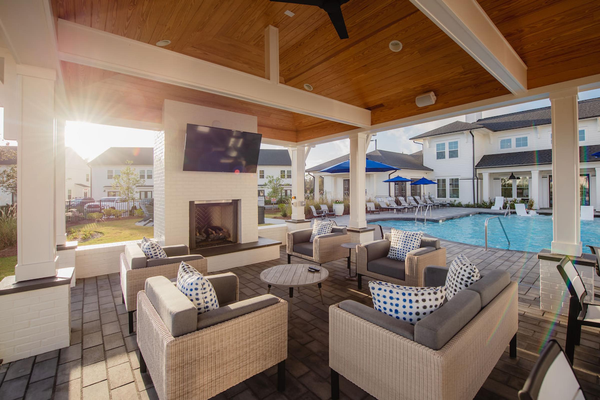 a covered patio with a fireplace and wicker furniture