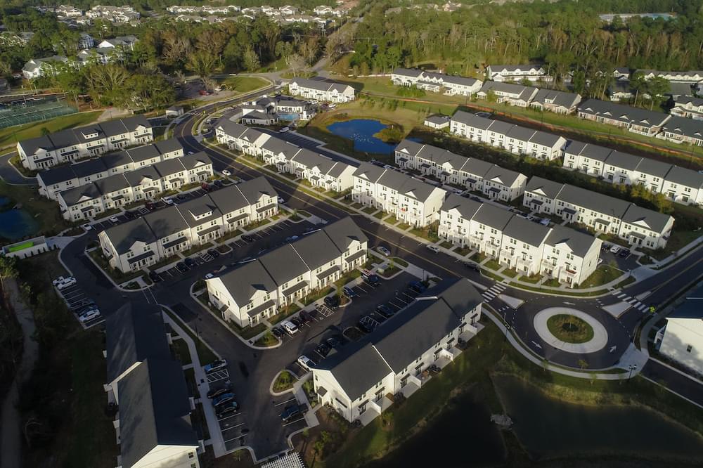 an aerial view of a row of apartment buildings next to a body of water