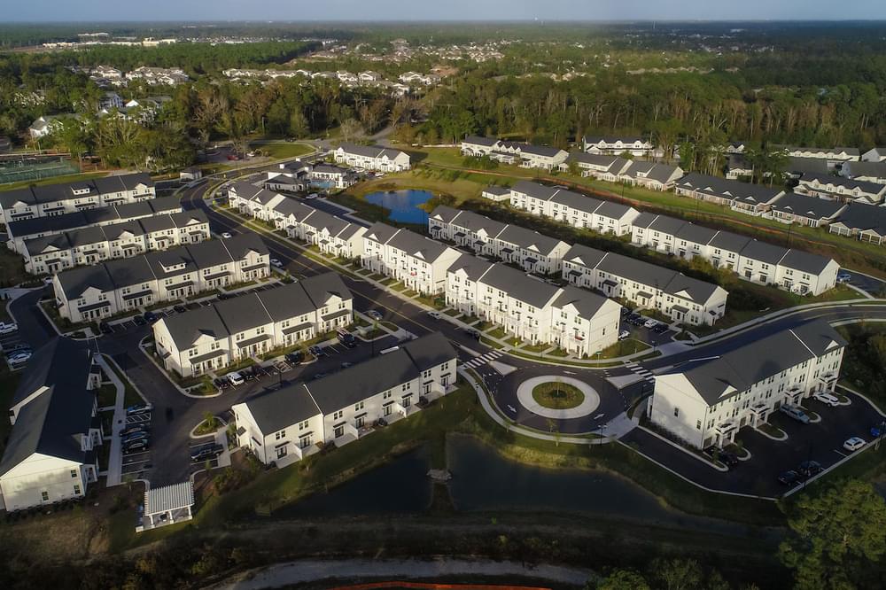 an aerial view of a large complex of condominiums in a wooded area