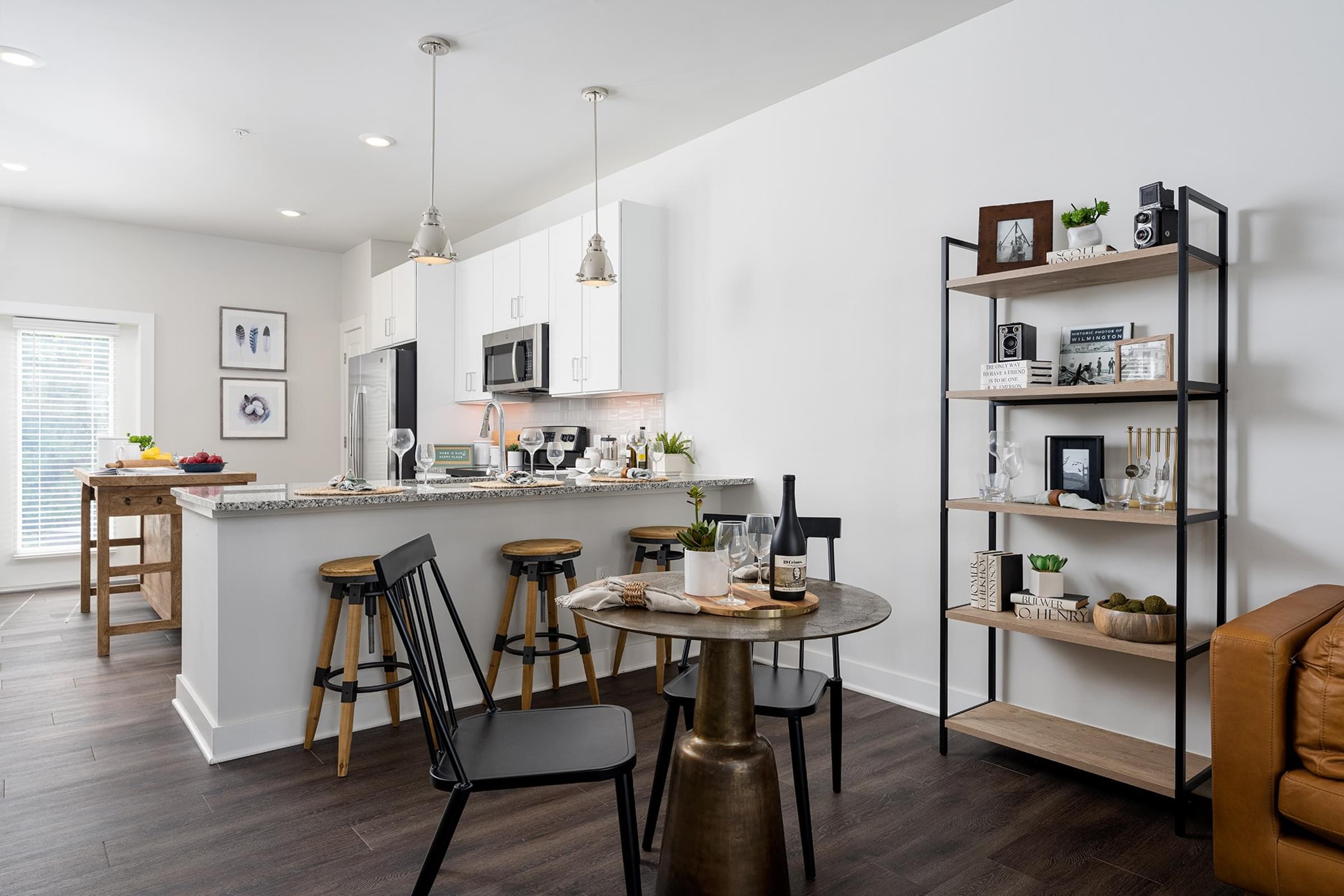 A modern kitchen with a bar area and a dining table set up.