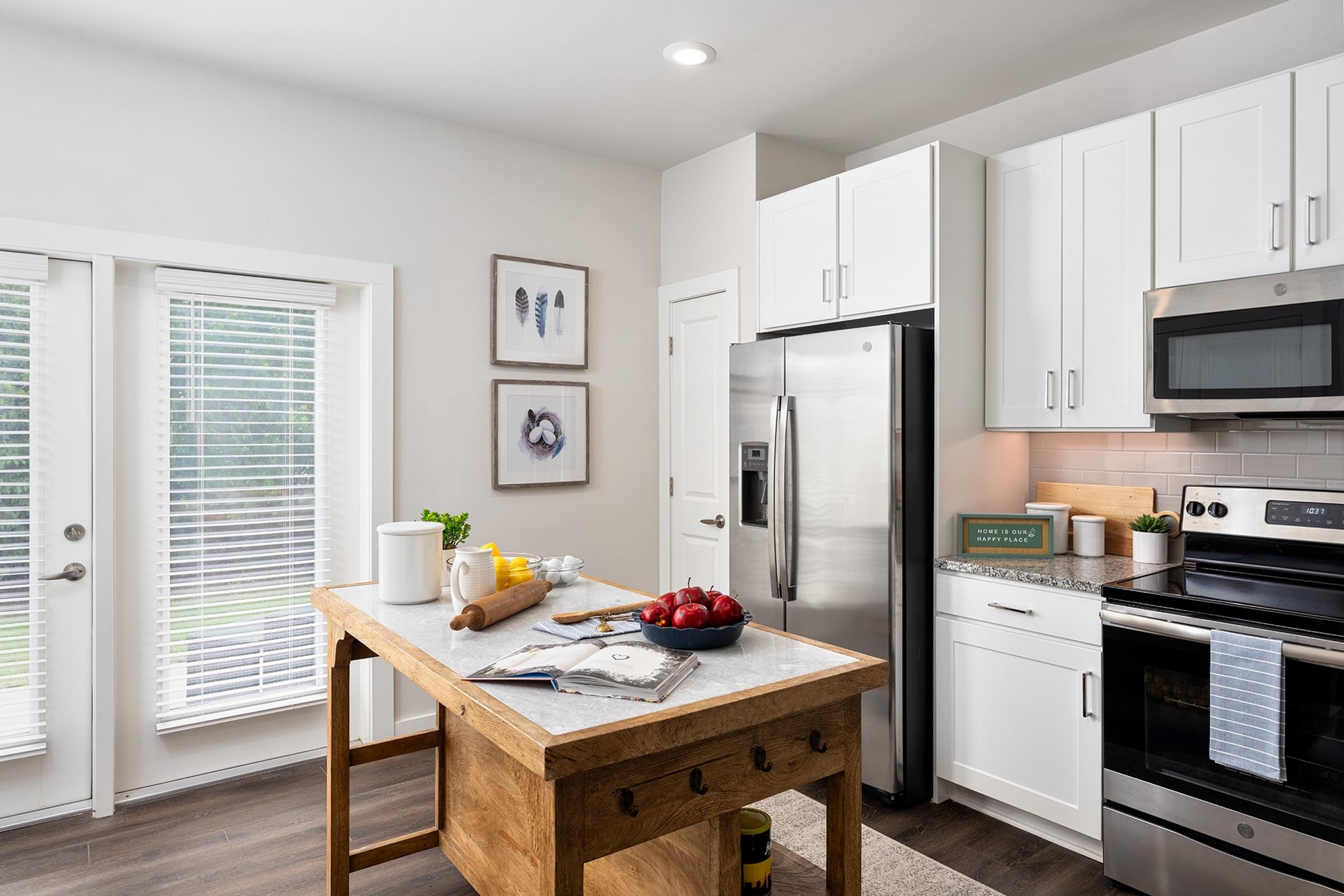 A kitchen with a wooden table and stainless steel appliances.