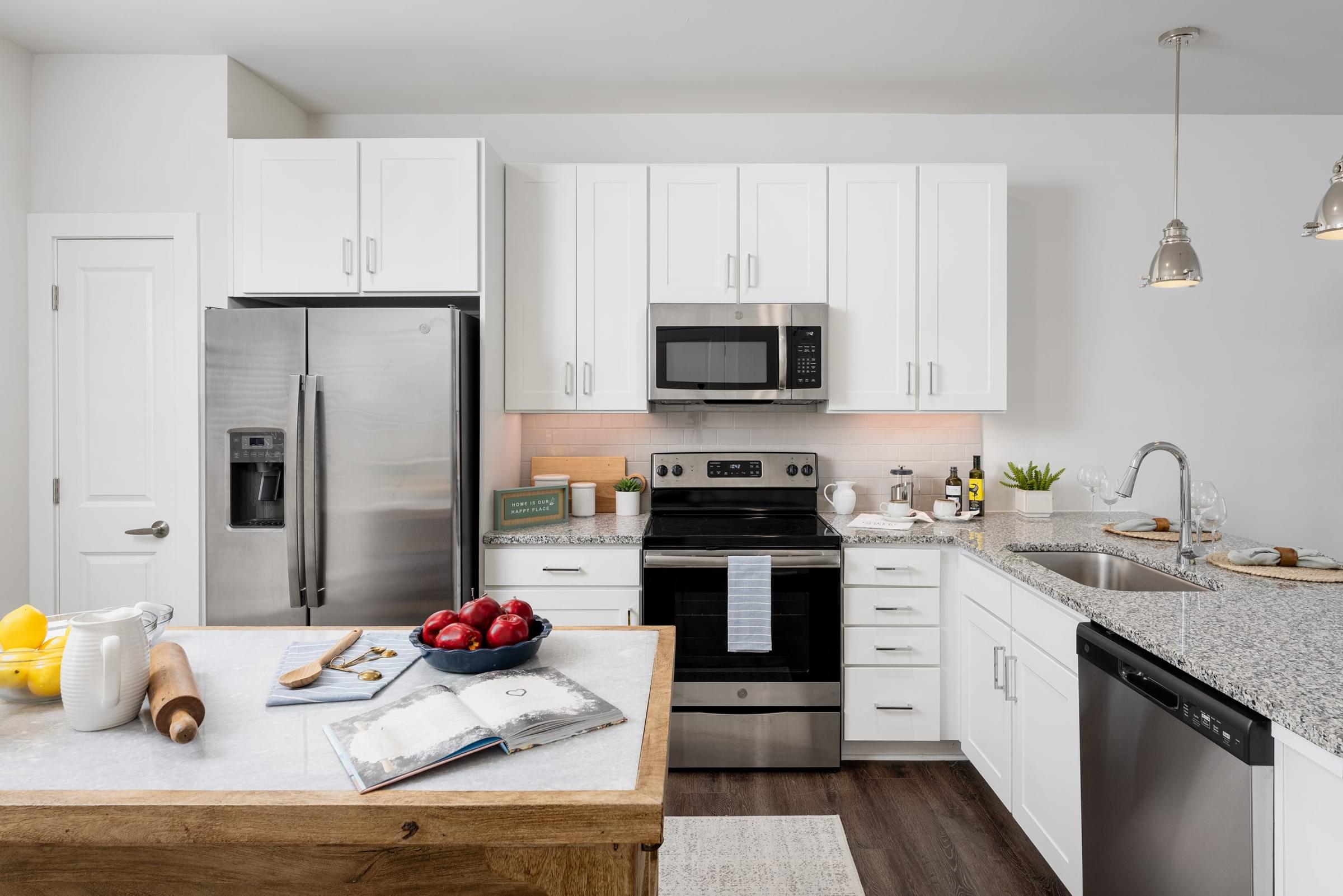 A modern kitchen with white cabinets and stainless steel appliances.