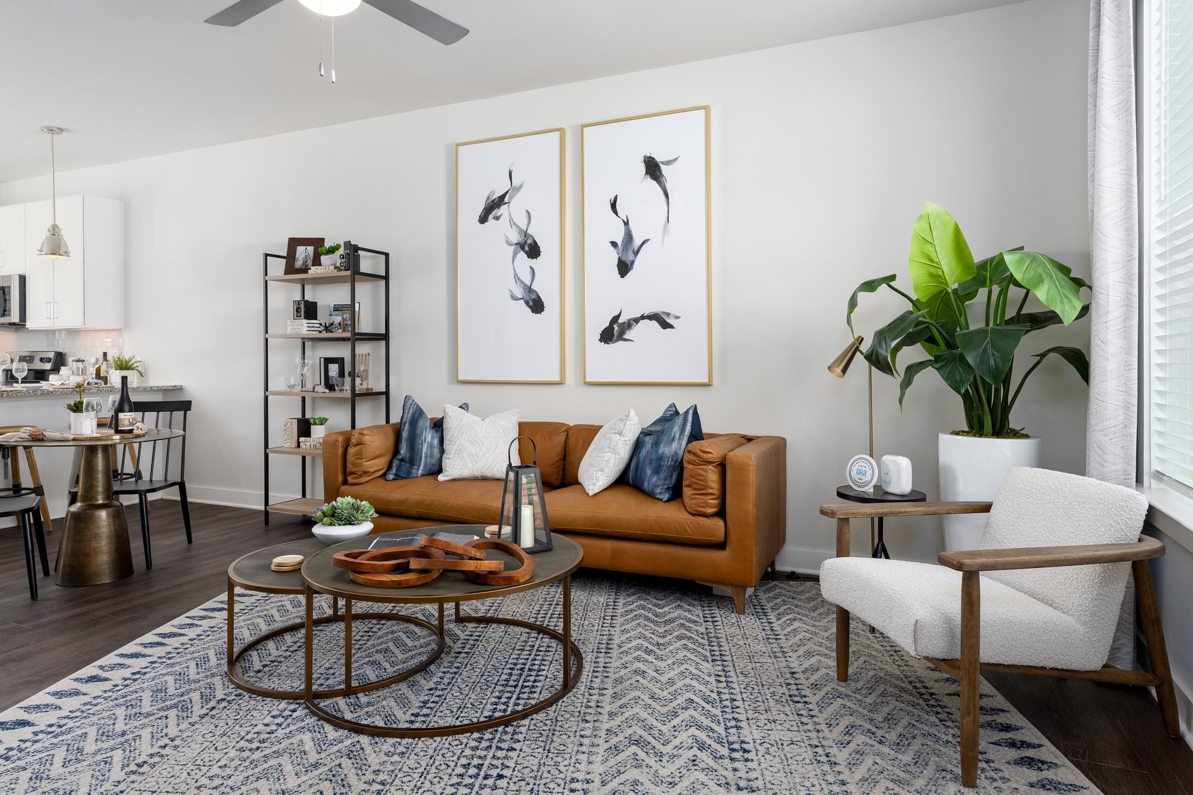 A living room with a brown couch, a coffee table, and a plant.