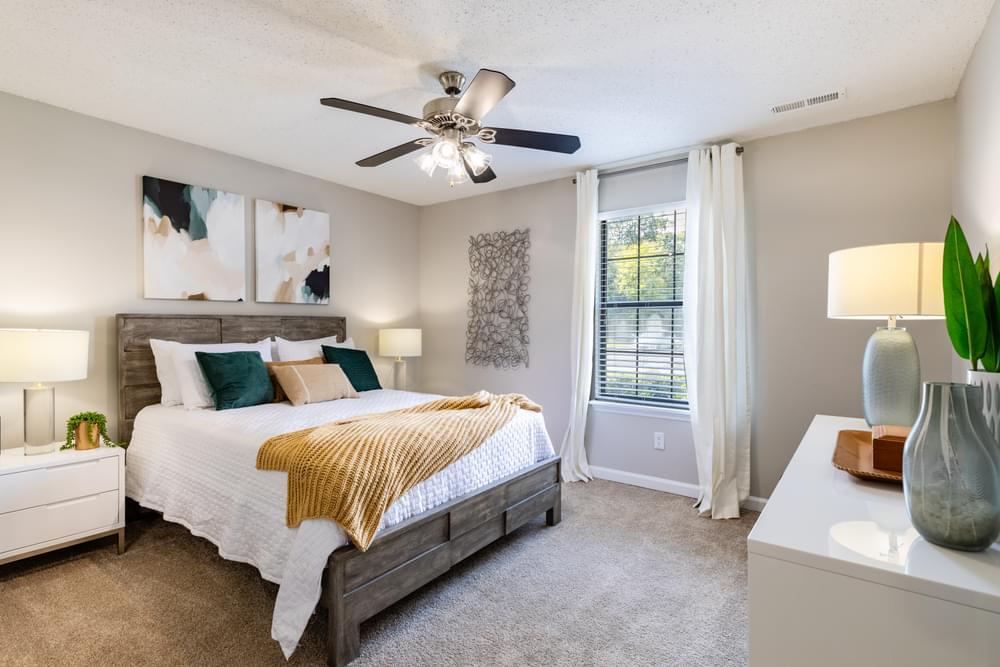 spacious bedroom with ceiling fan and window at the preserve at greatstone