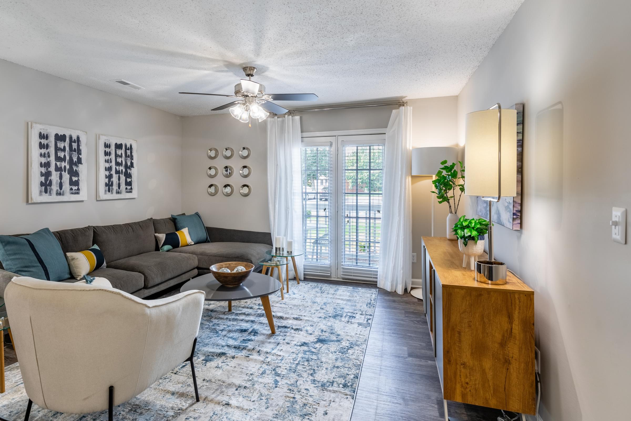 Living Room with hardwood Inspired Vinyl Flooring, Designer Ceiling Fans with Lighting, and Private Patio