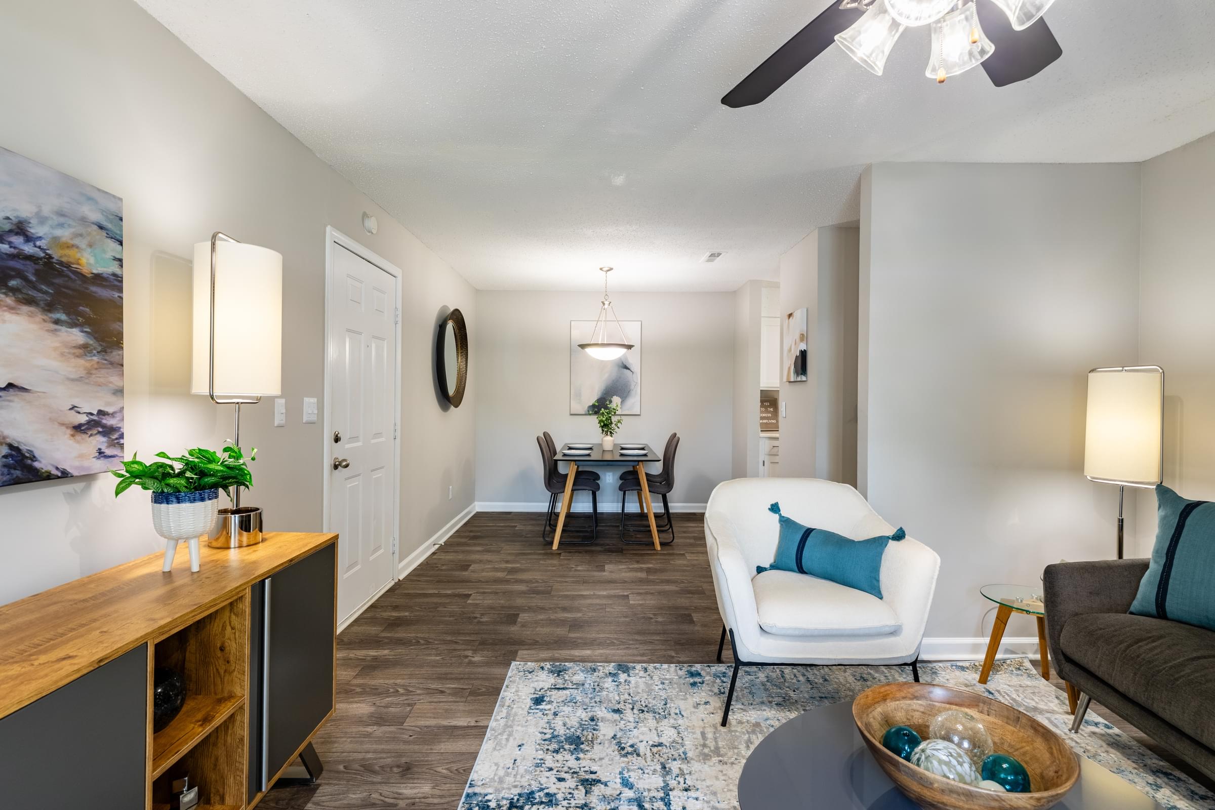 the living room and dining room of an apartment with a table and chairs