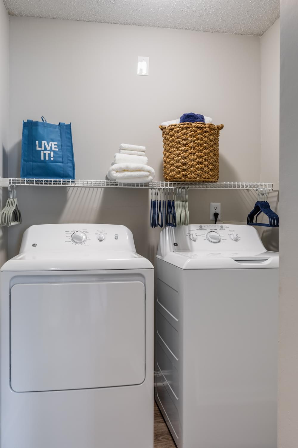 a white washer and dryer in a laundry room with a basket on top