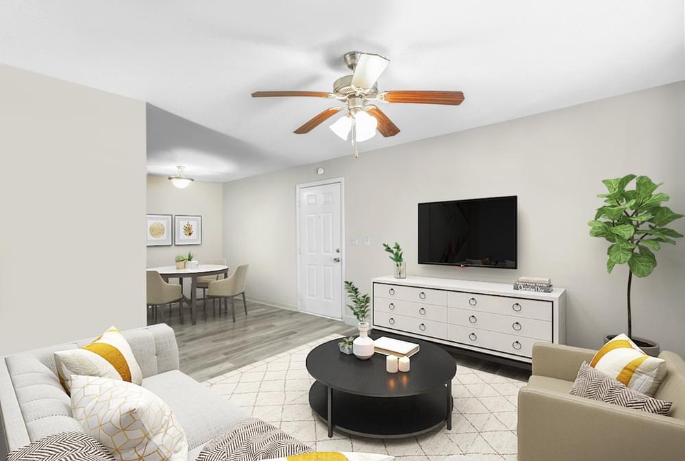 a living room with a ceiling fan and a tv on the wall