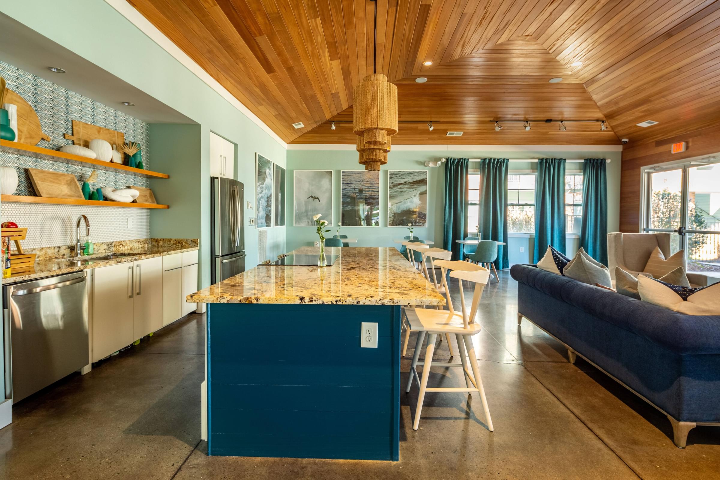 A kitchen with a blue island and wooden ceiling
