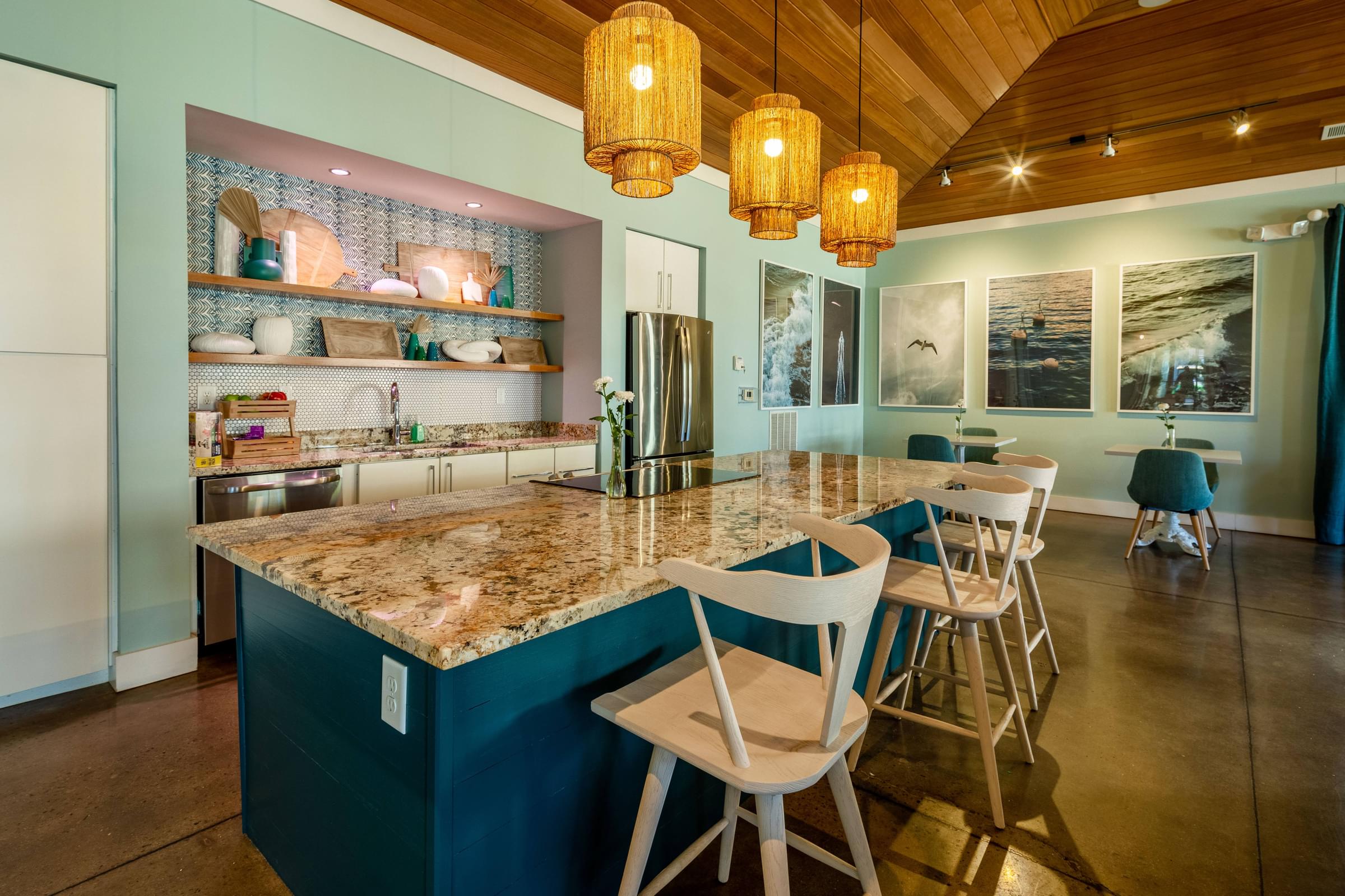 A kitchen with a granite countertop and white chairs