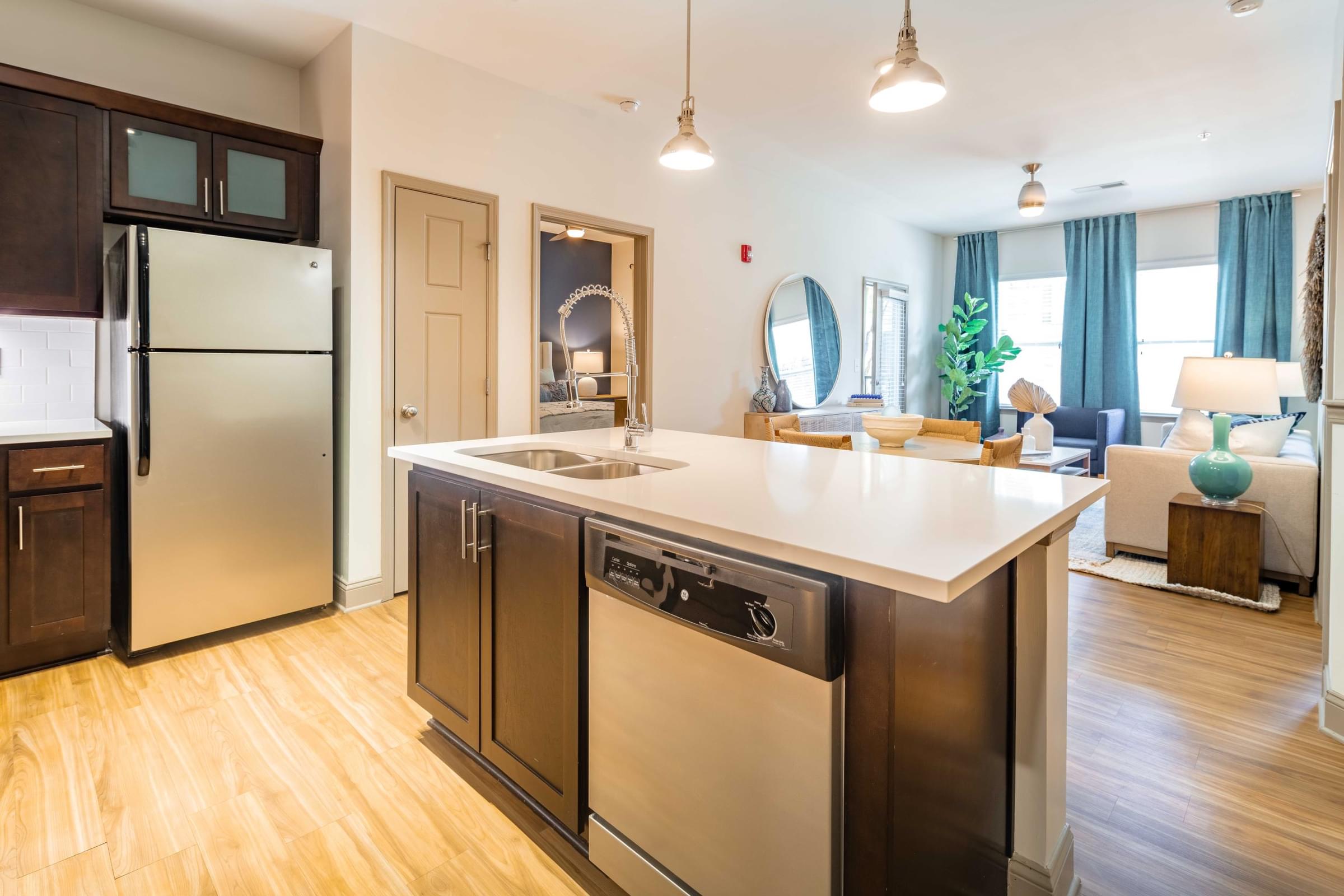 A modern kitchen with a refrigerator, dishwasher, and stove top oven