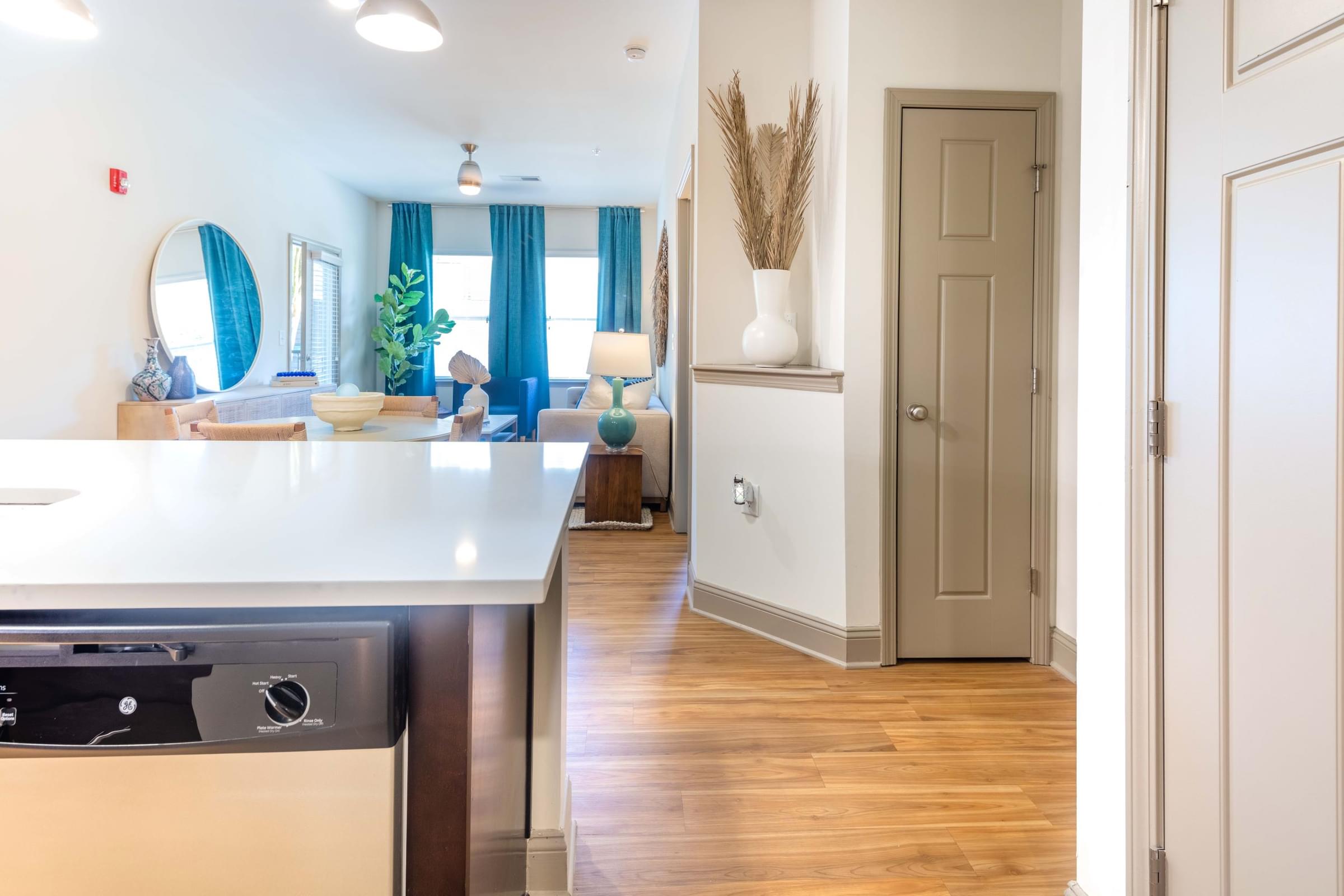 A kitchen with a white counter top and a dishwasher