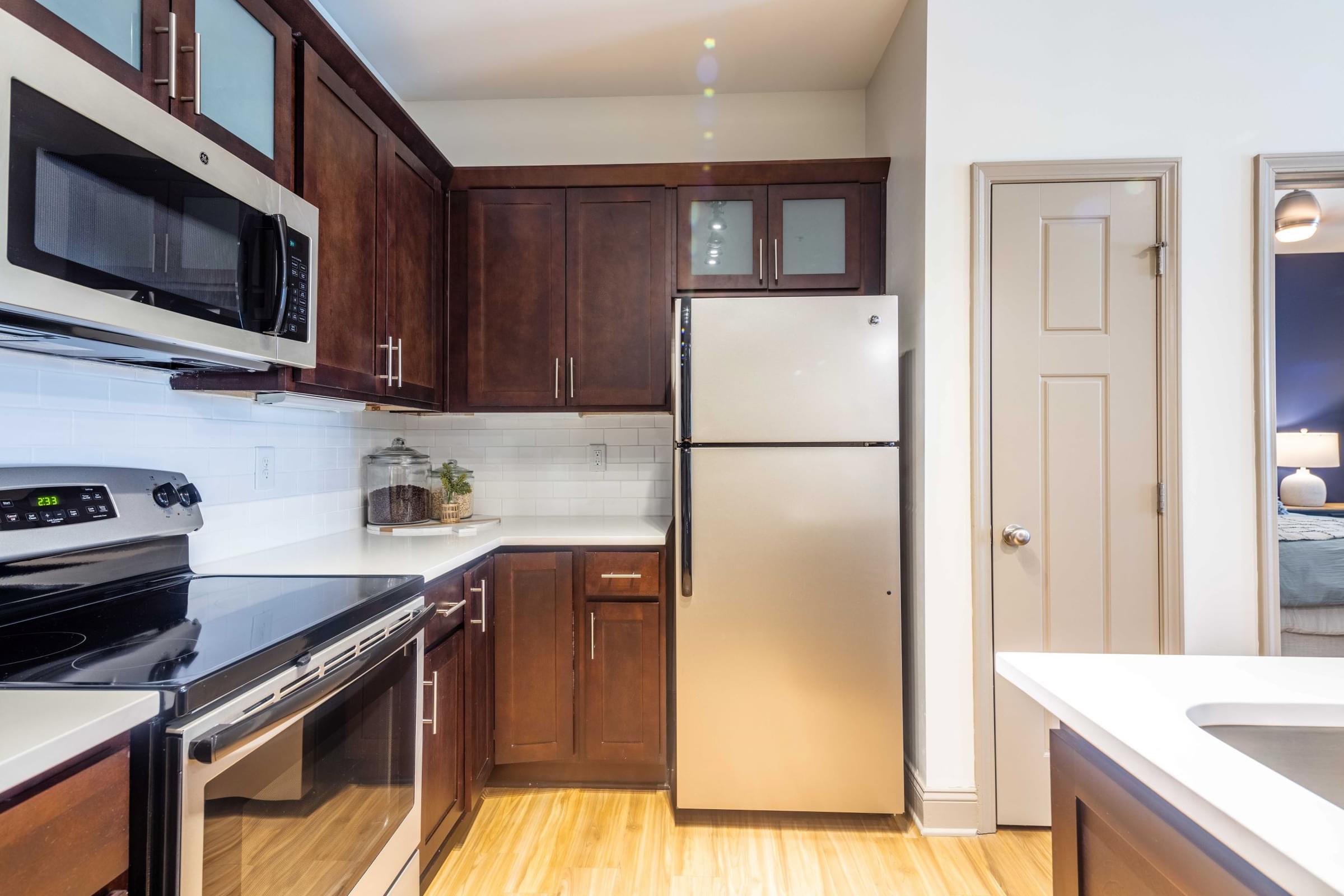 Kitchen with Dark Wood Cabinets, GE Silver Appliances and Pantry