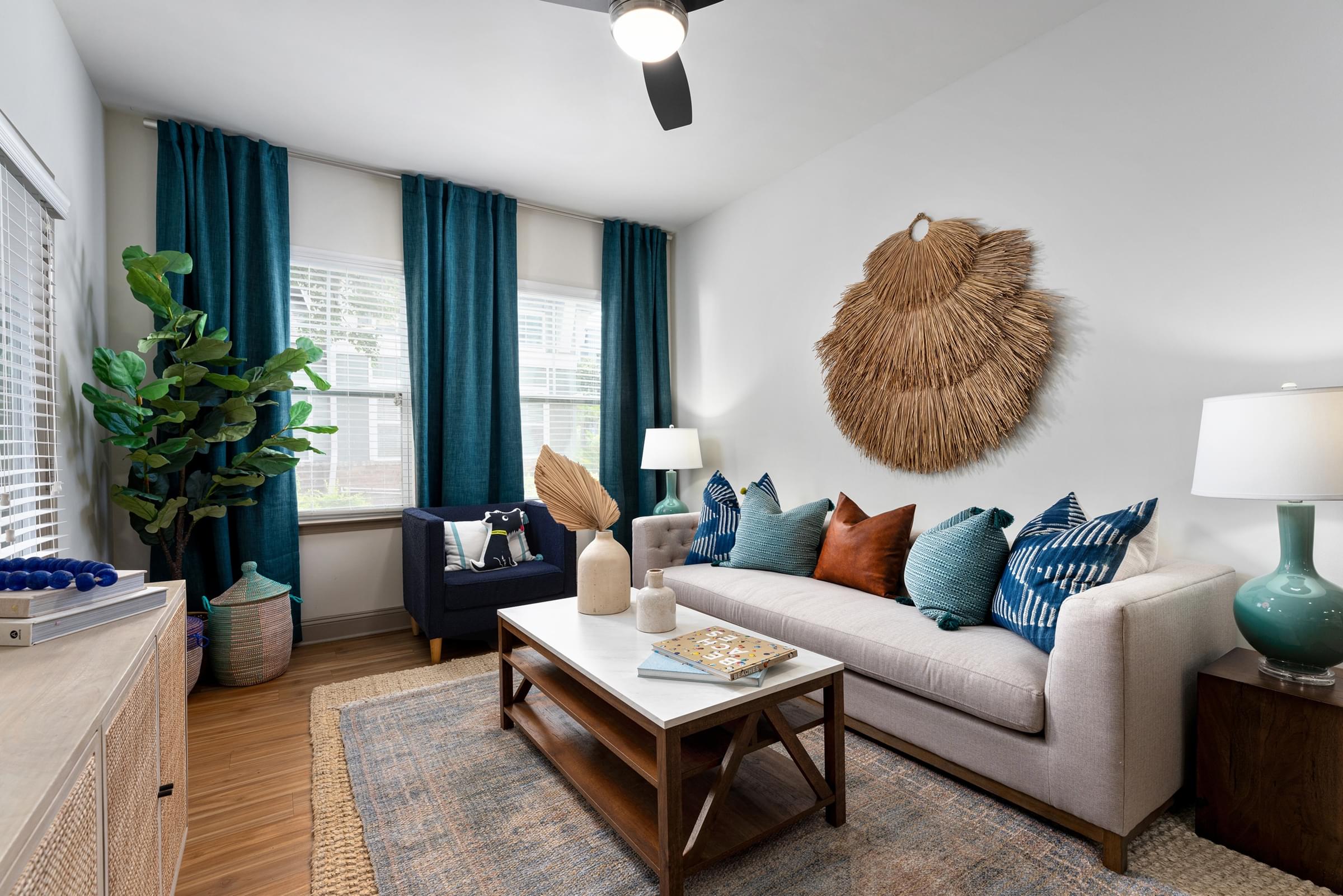 A living room with a couch, a coffee table, and a wall hanging.