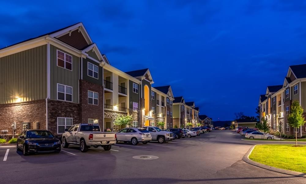 a row of apartment buildings on a street at night