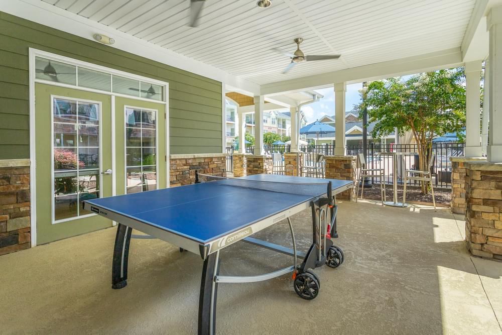 a ping pong table on the covered patio of a house