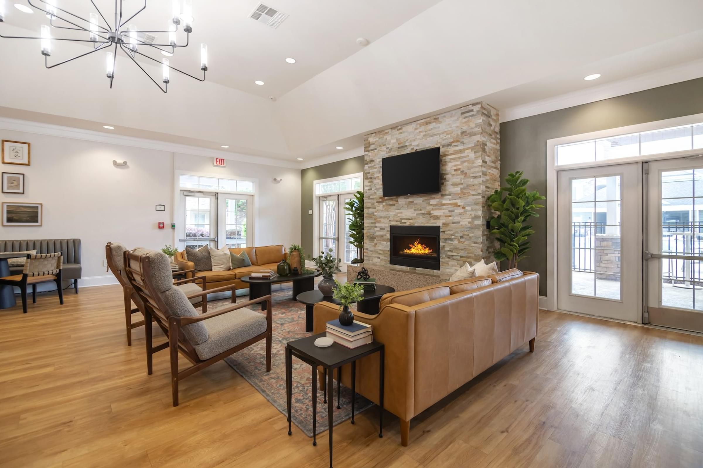 A modern living room with a stone fireplace and wooden furniture.