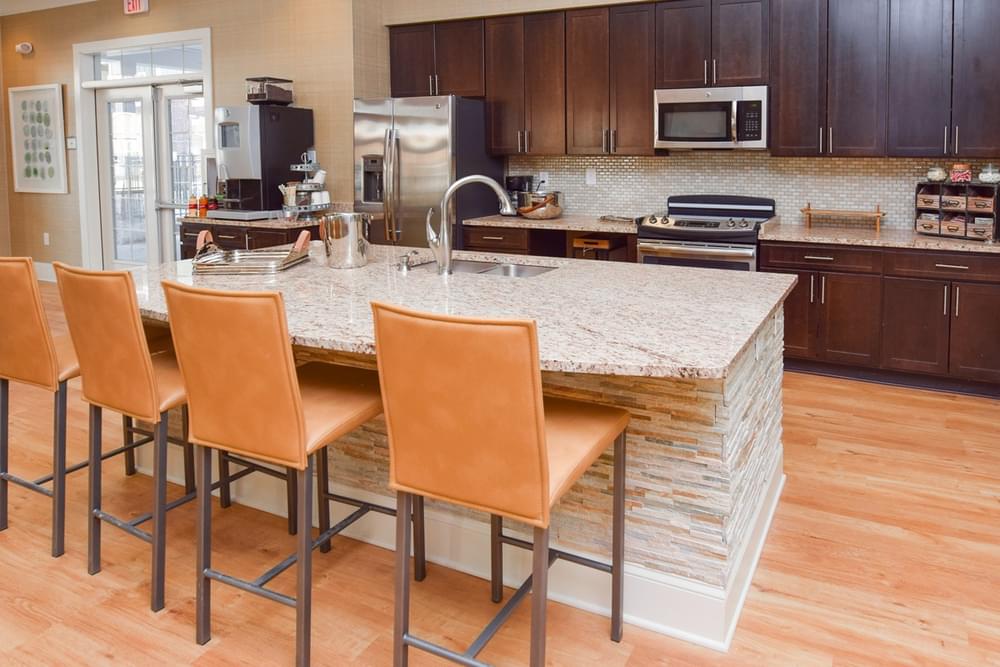 a kitchen with a large island with chairs and a sink