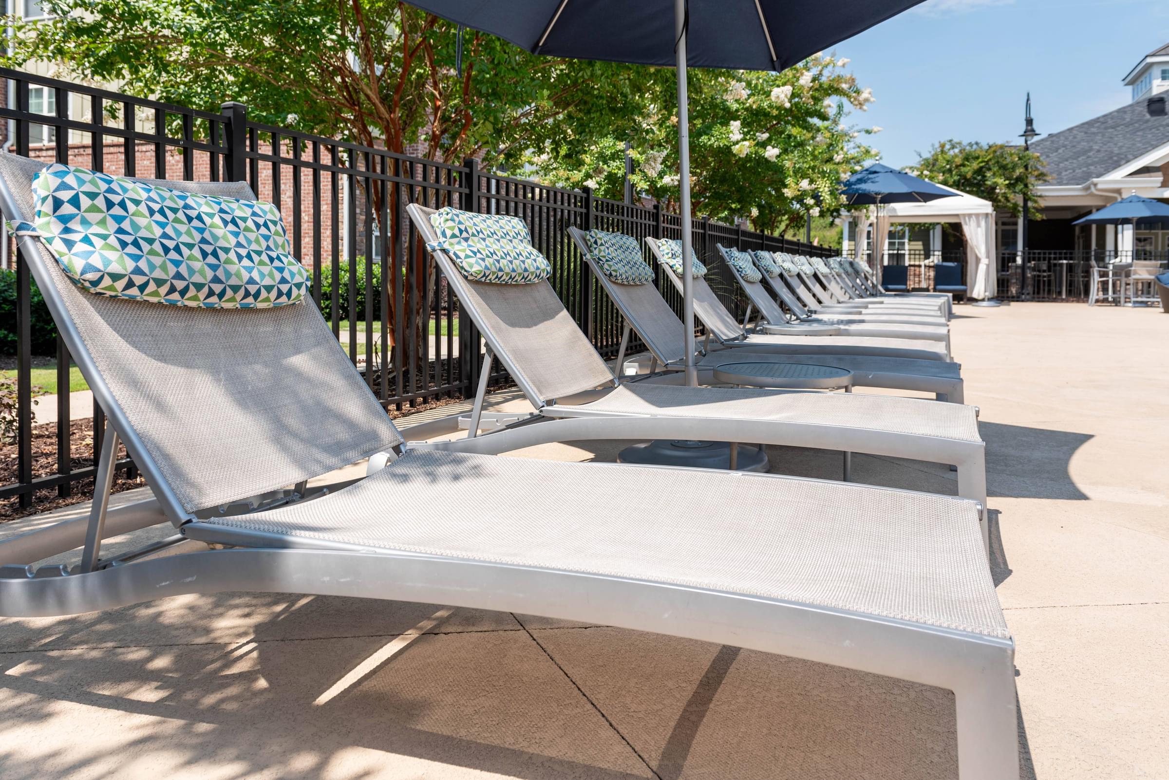 a row of chaise lounges with umbrellas
