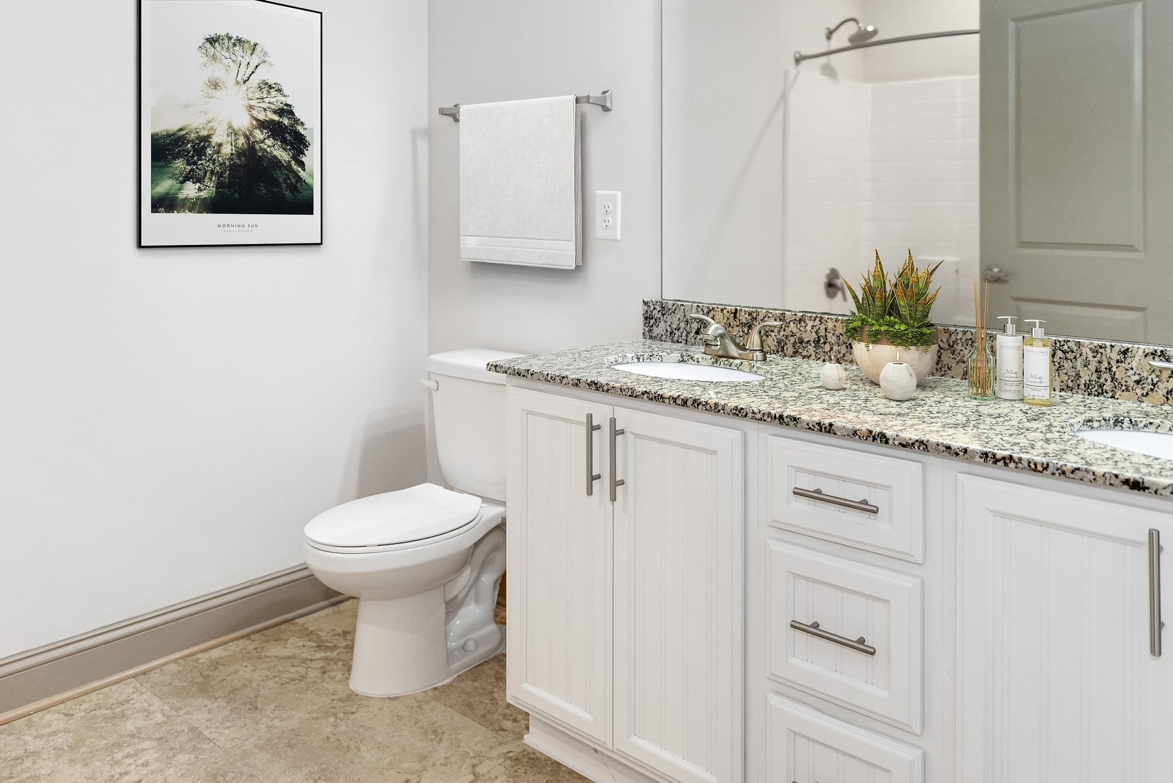 a bathroom with white cabinets and a white toilet
