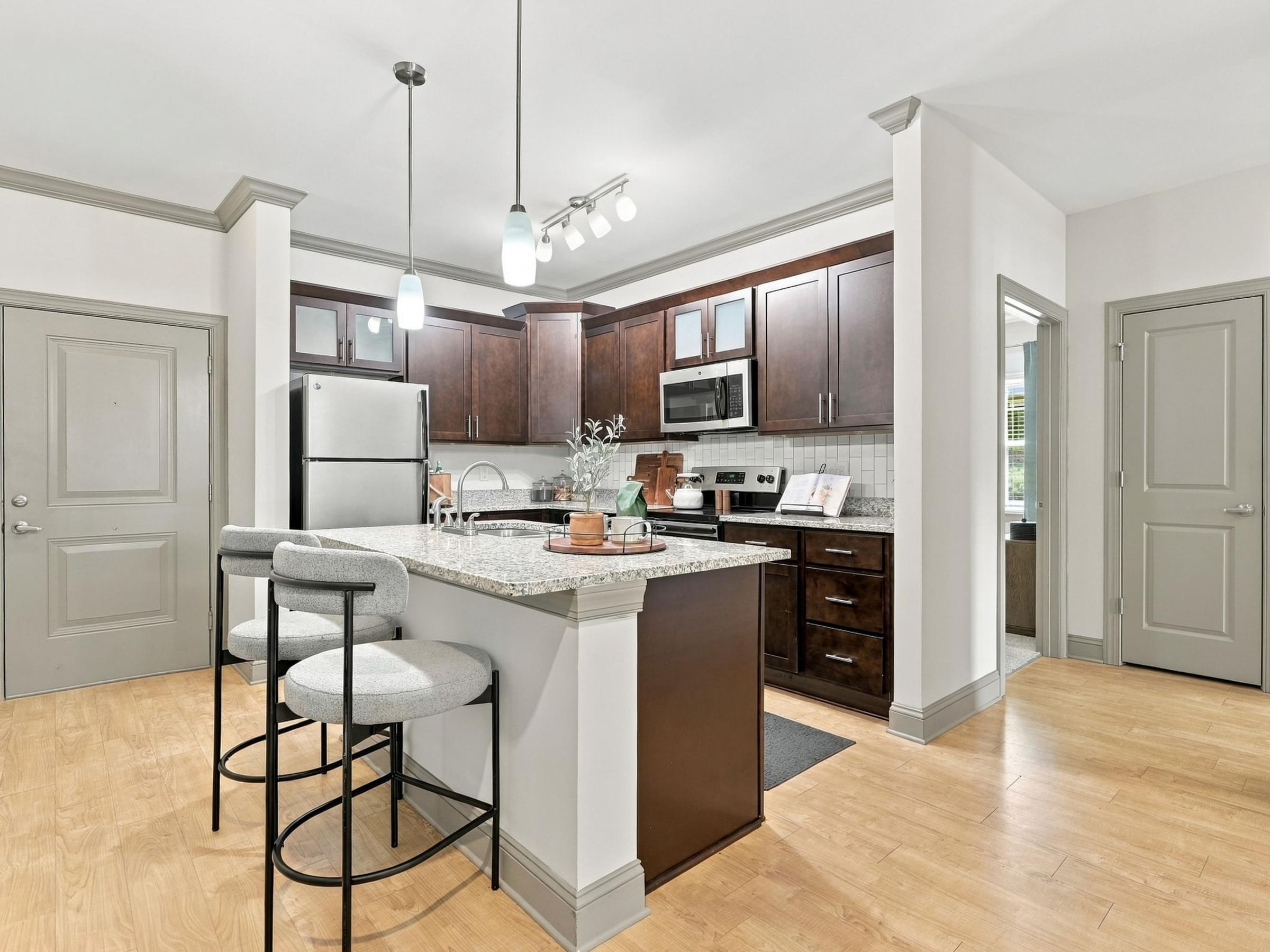 A kitchen with a white fridge and a bar area.