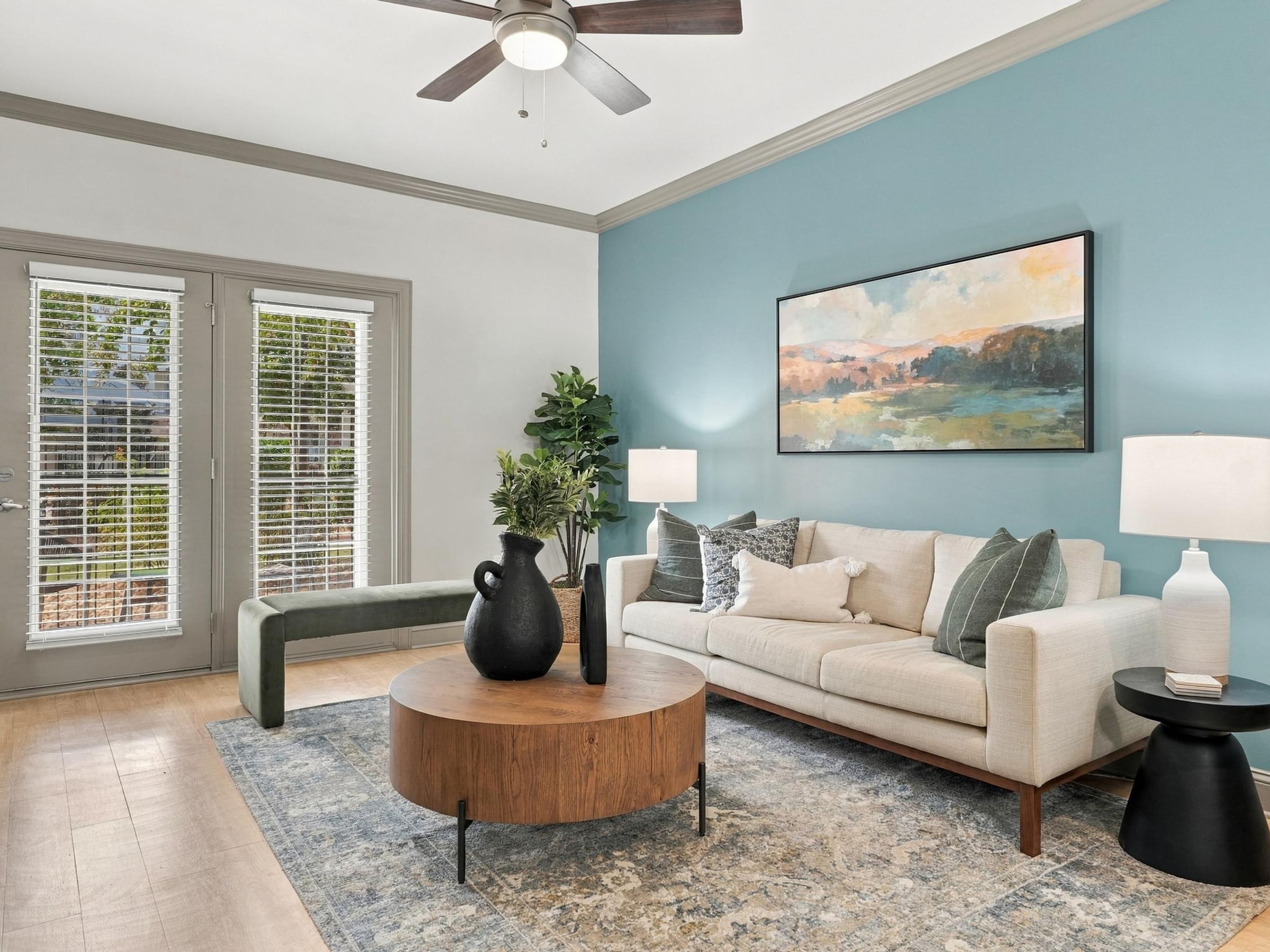 A living room with a white couch, a coffee table, and a painting on the wall.