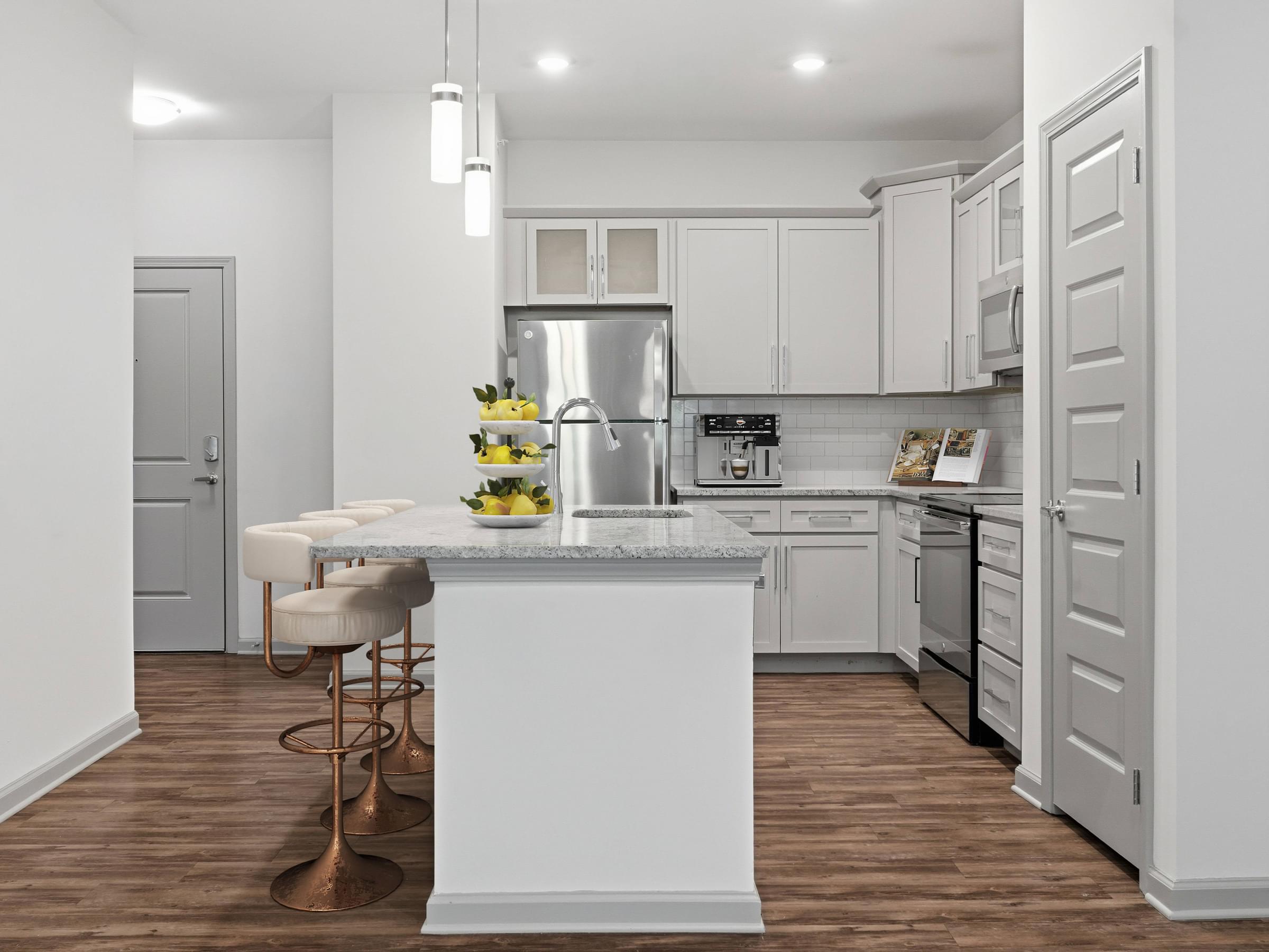A kitchen with a white island and stools.