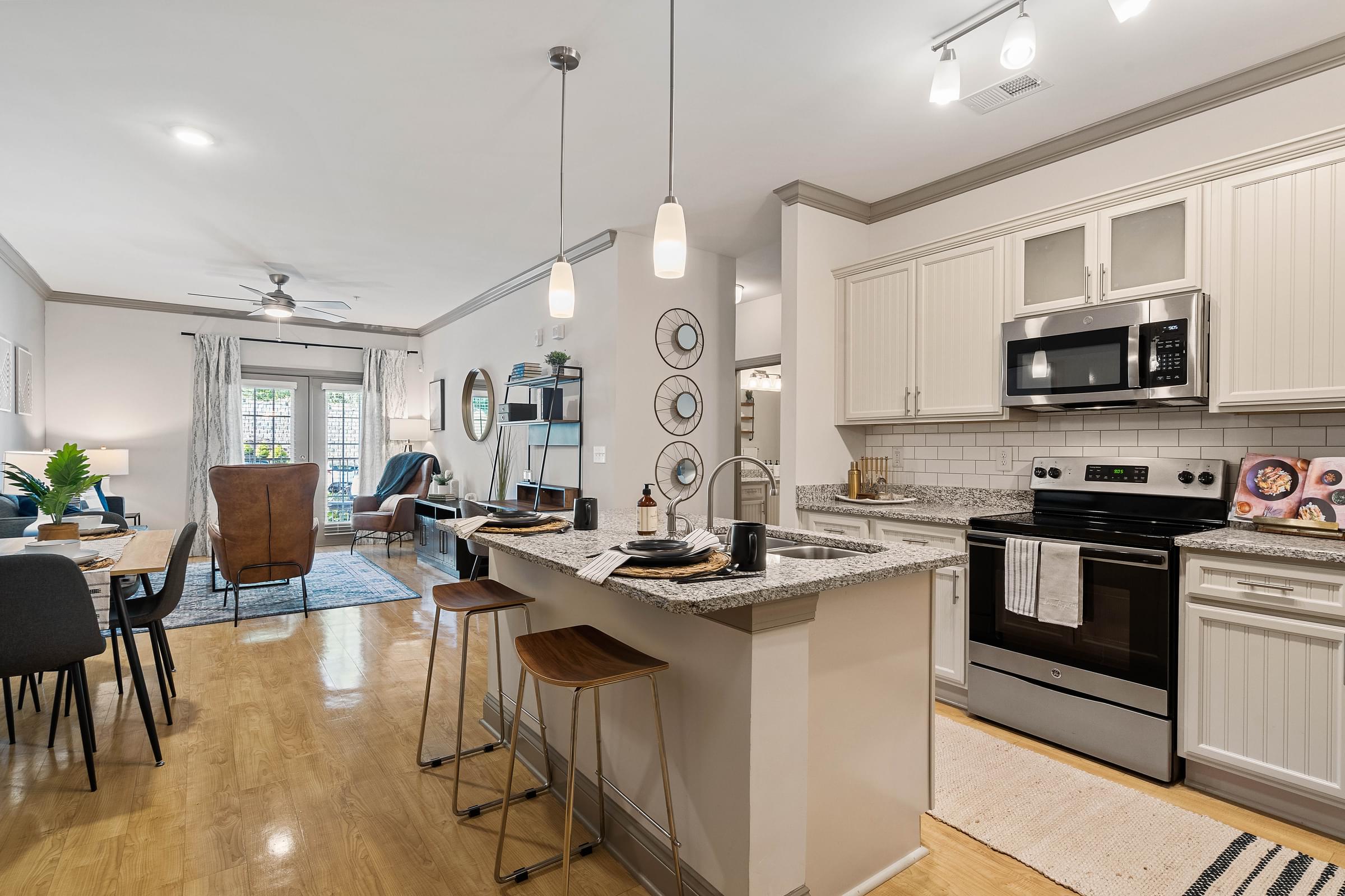a kitchen with an island and a living room with a table and chairs