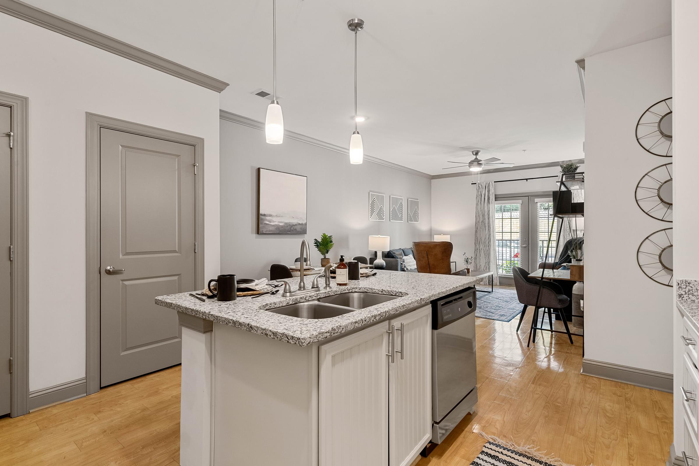 the kitchen and living room of a house with a counter top and a sink