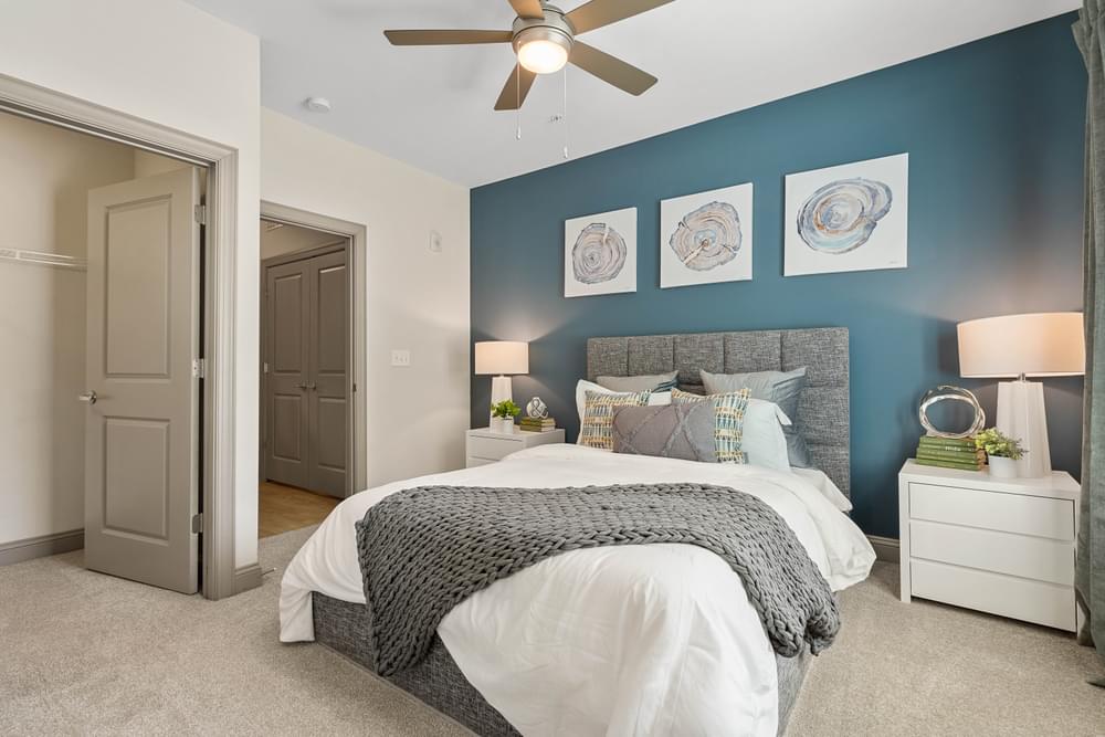 a blue and white bedroom with a bed and a ceiling fan