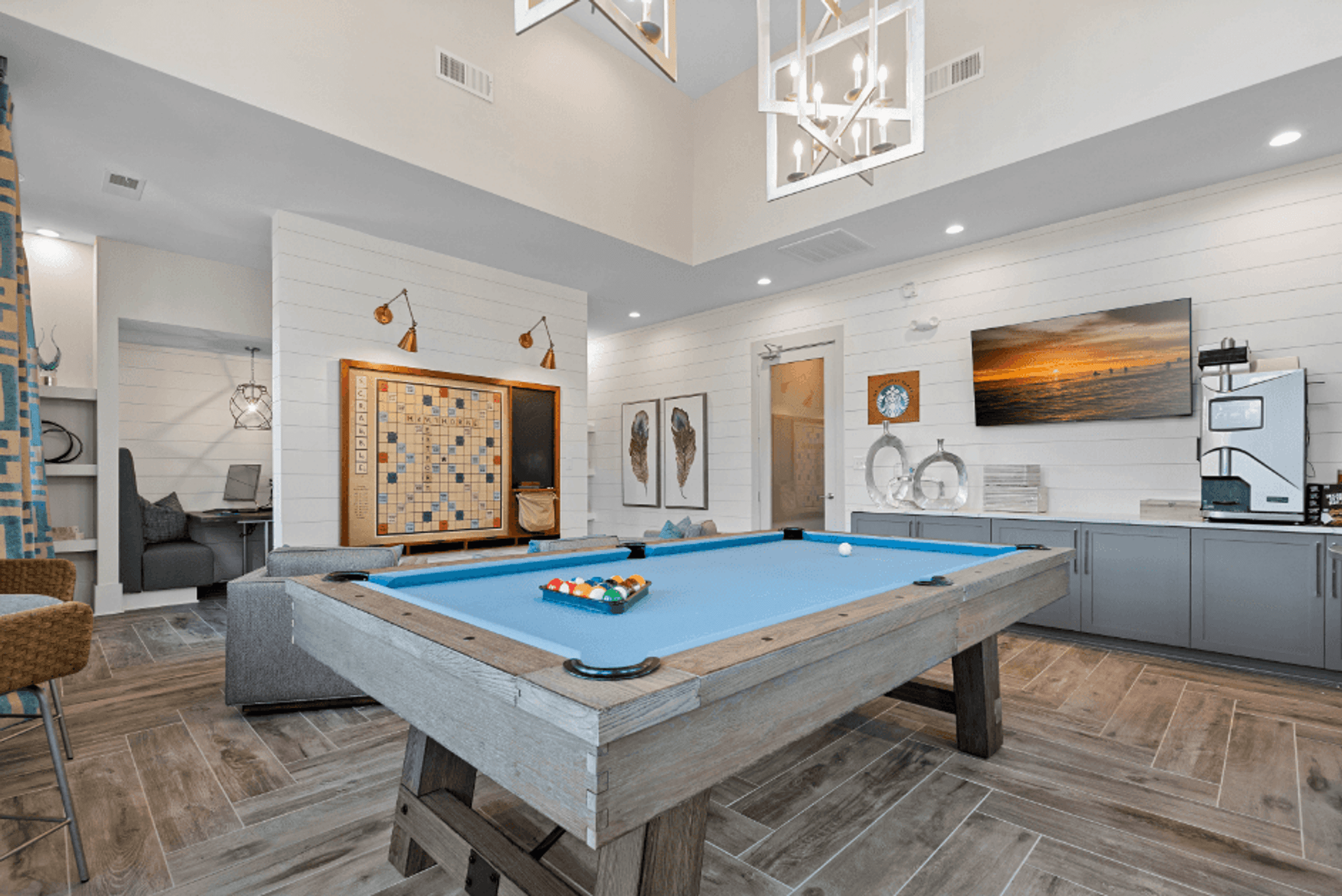 a pool table in a living room with a game system and a tv