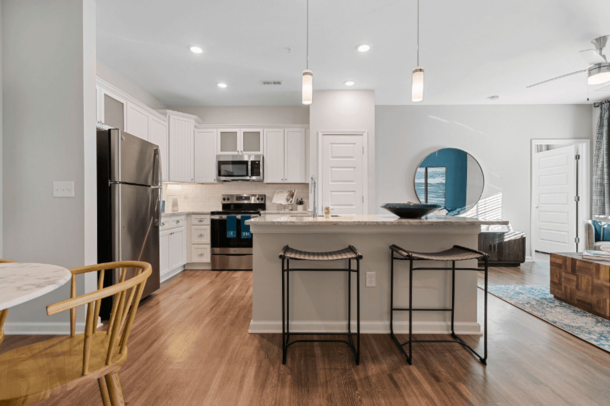 Spacious Kitchen with White Cabinets and a Large Island with Granite Countertops