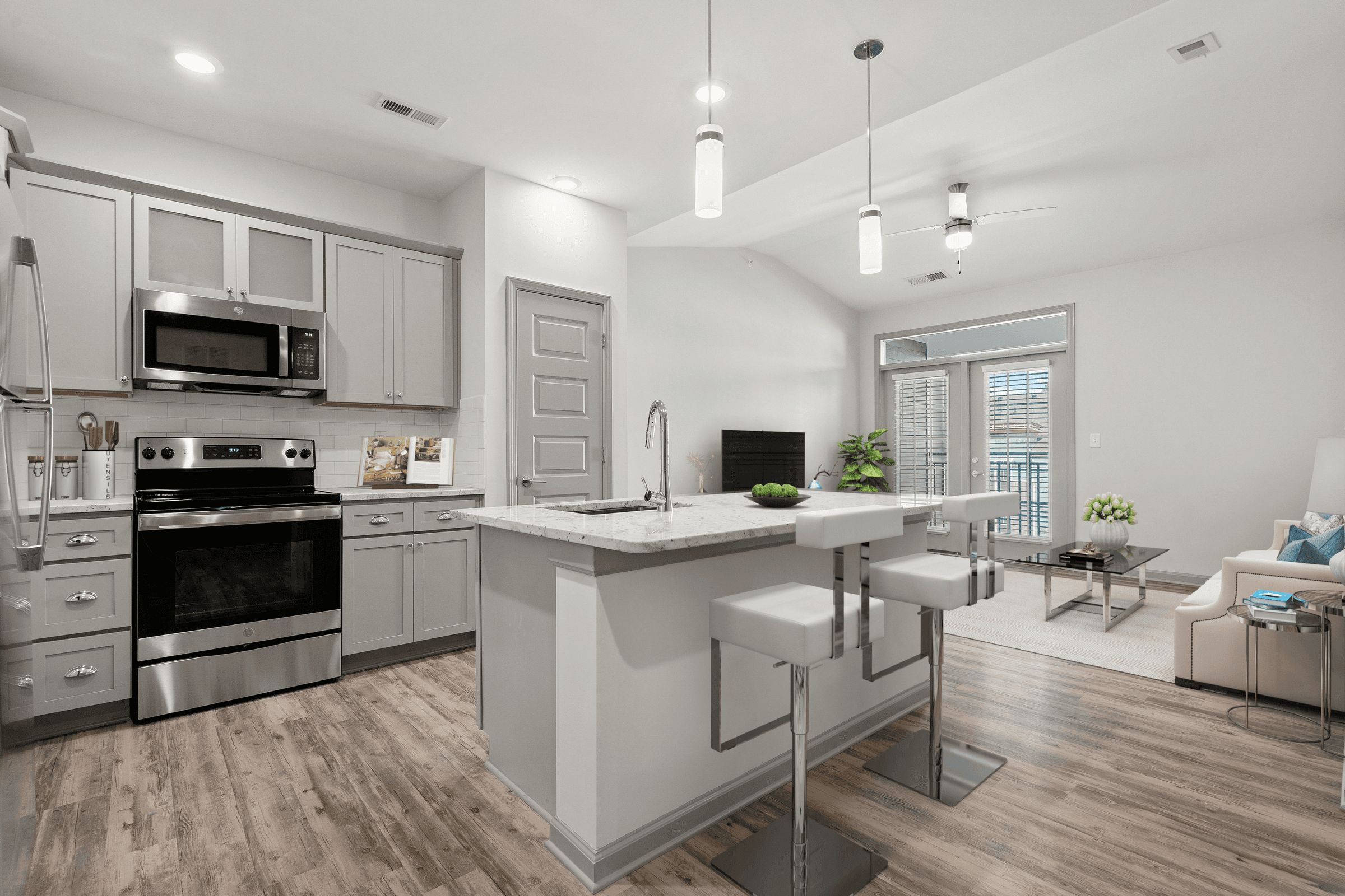 an open kitchen and living room with a large island and white cabinets