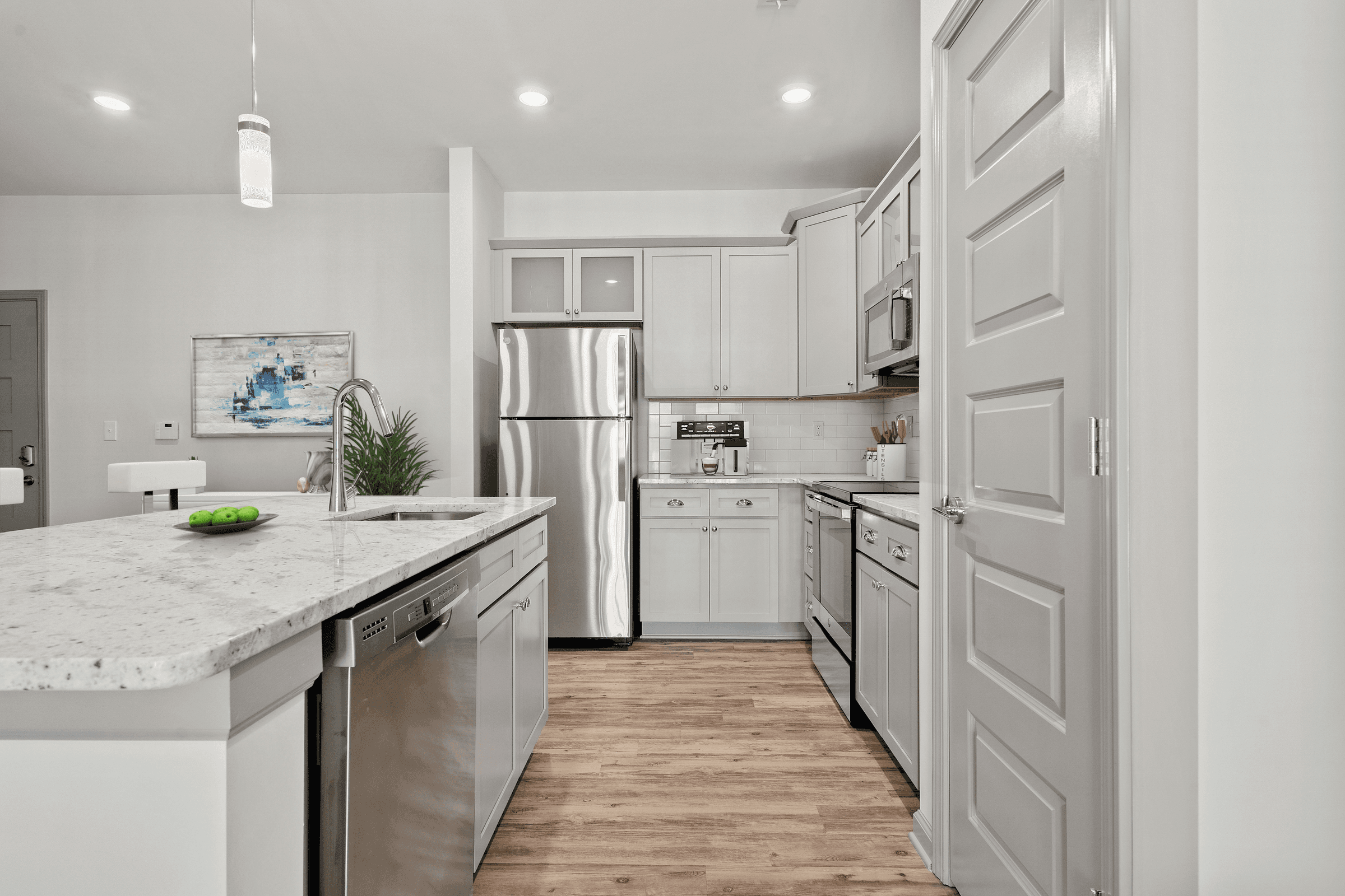 an open kitchen with white cabinets and stainless steel appliances