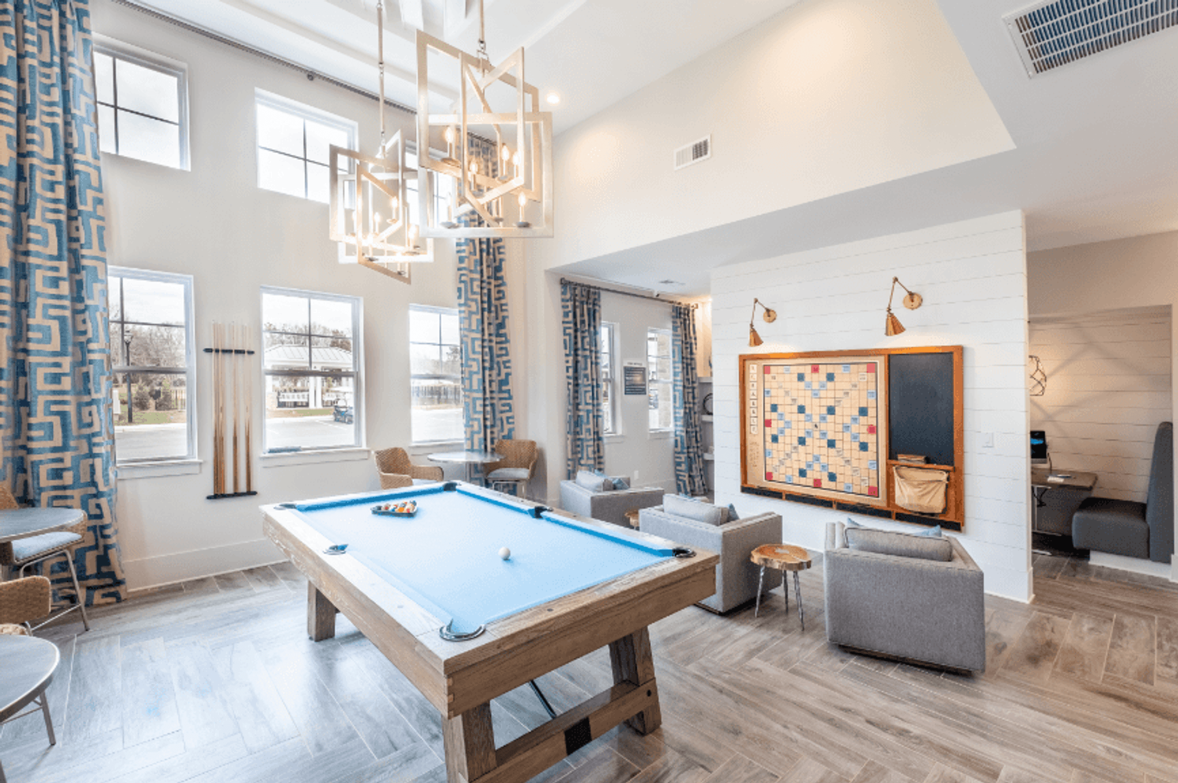 a spacious game room with a pool table and lounge-style seating