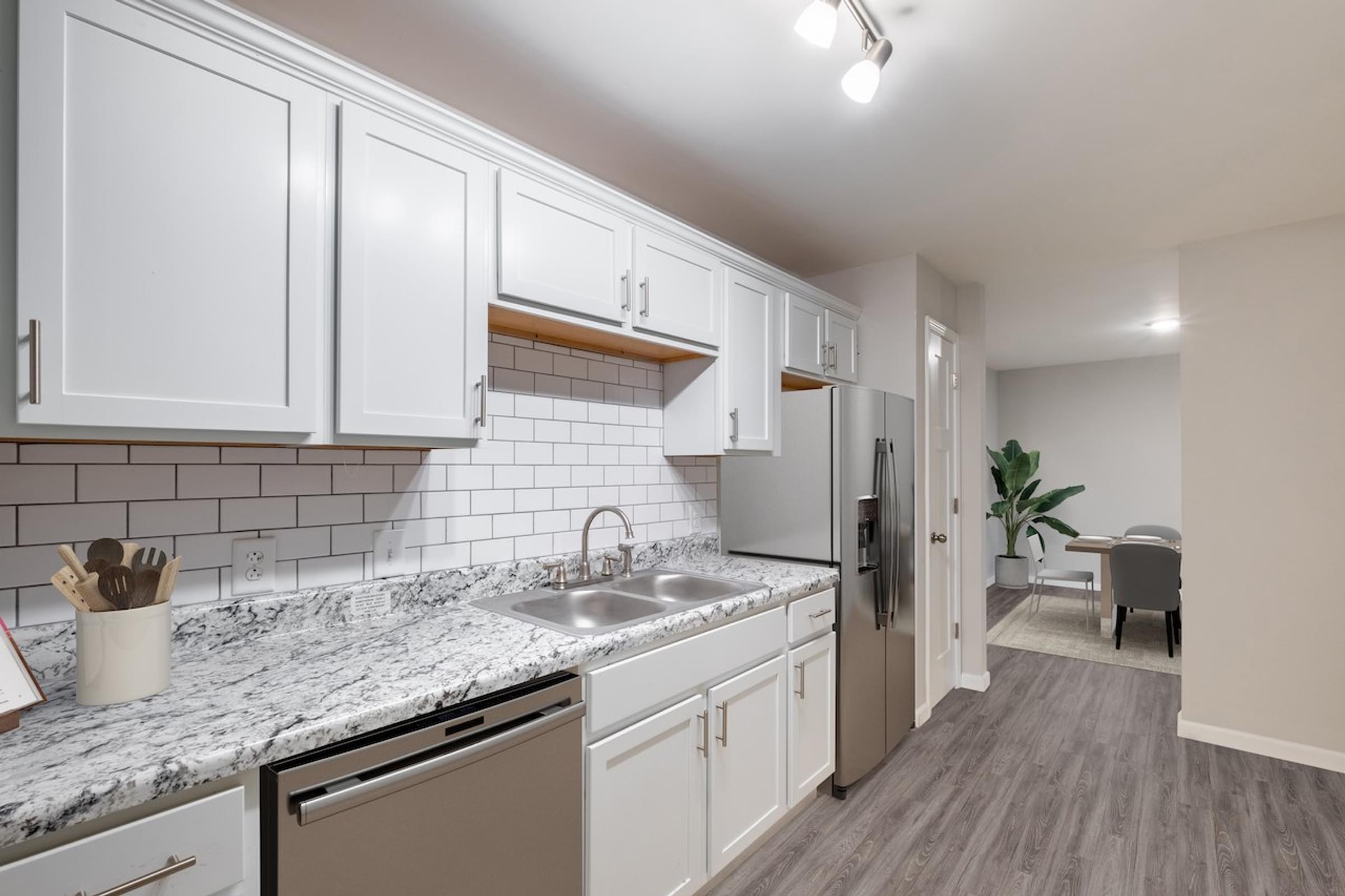 a kitchen with white cabinets and a granite countertop