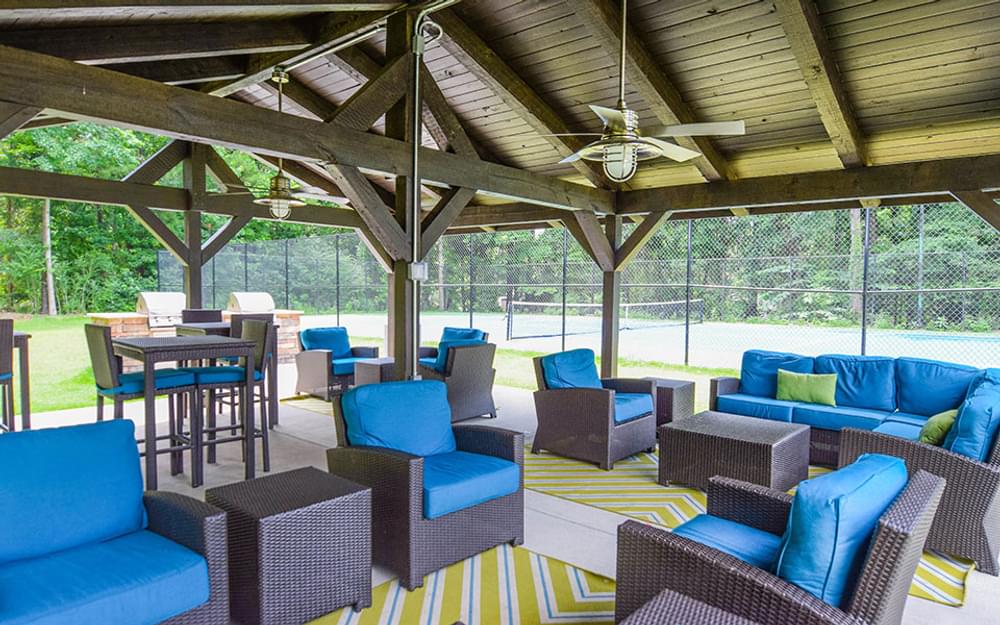 a patio with blue couches and chairs and tables