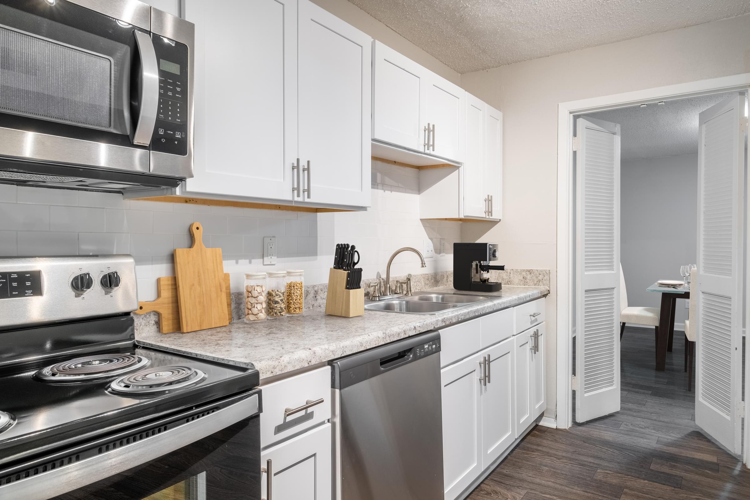 a kitchen with stainless steel appliances and white cabinets