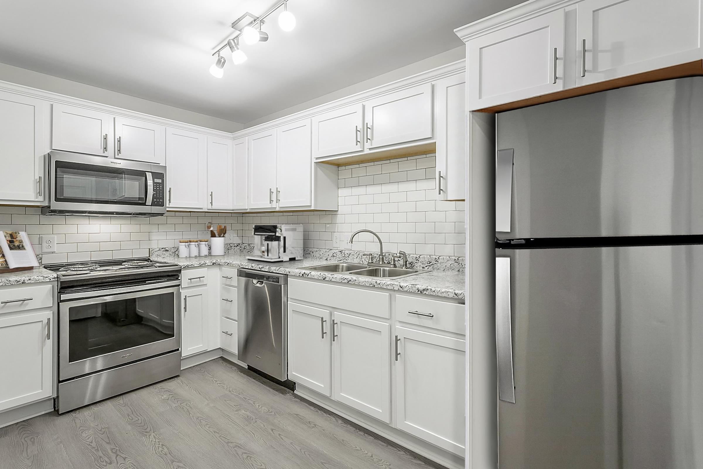 a kitchen with stainless steel appliances and white cabinets