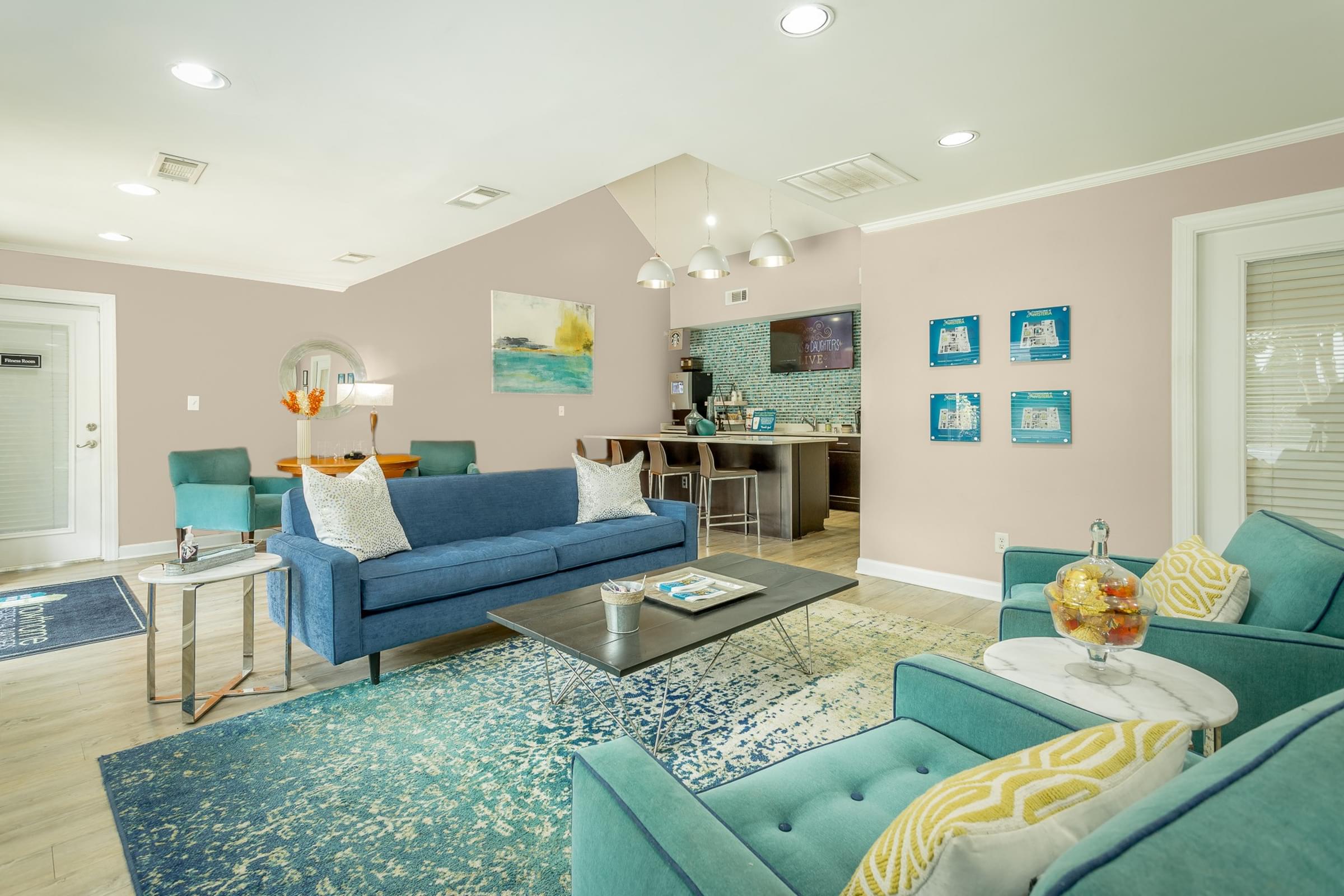a living room with blue couches and chairs and a rug