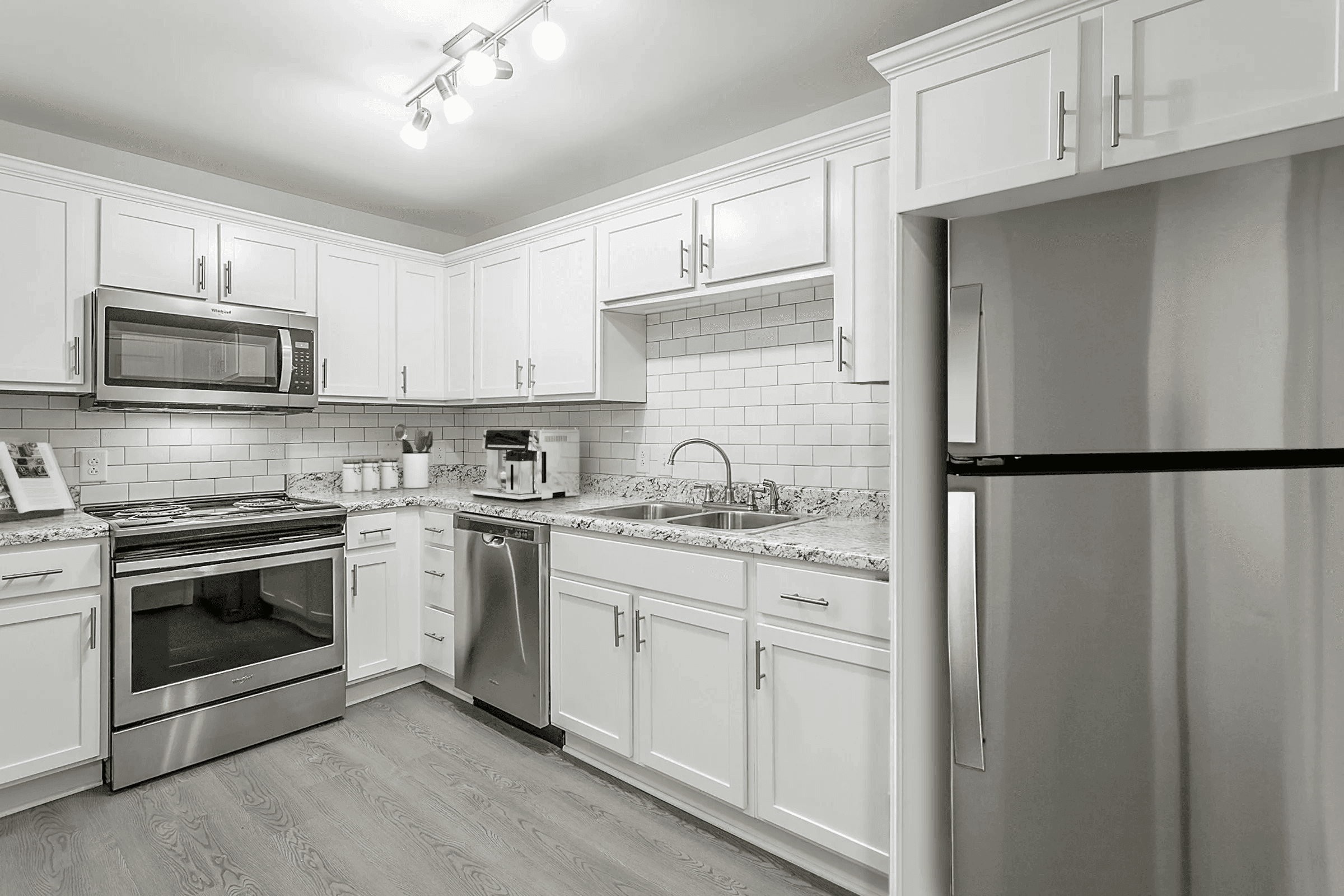 A kitchen with white cabinets and appliances.