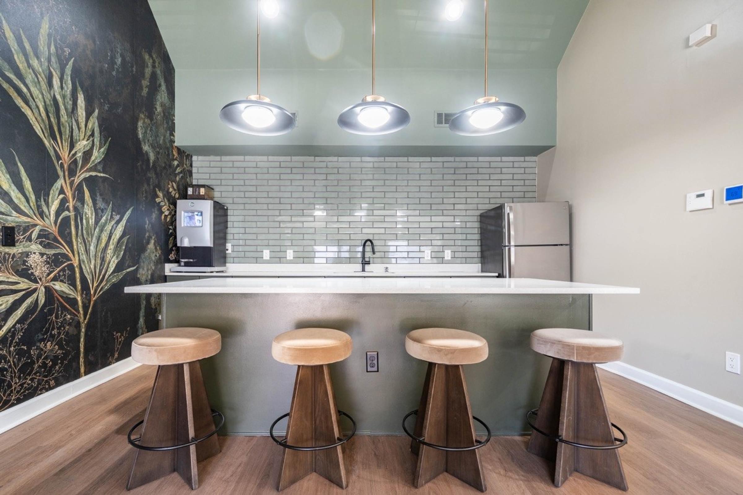 A kitchen with a bar area featuring a white counter and bar stools