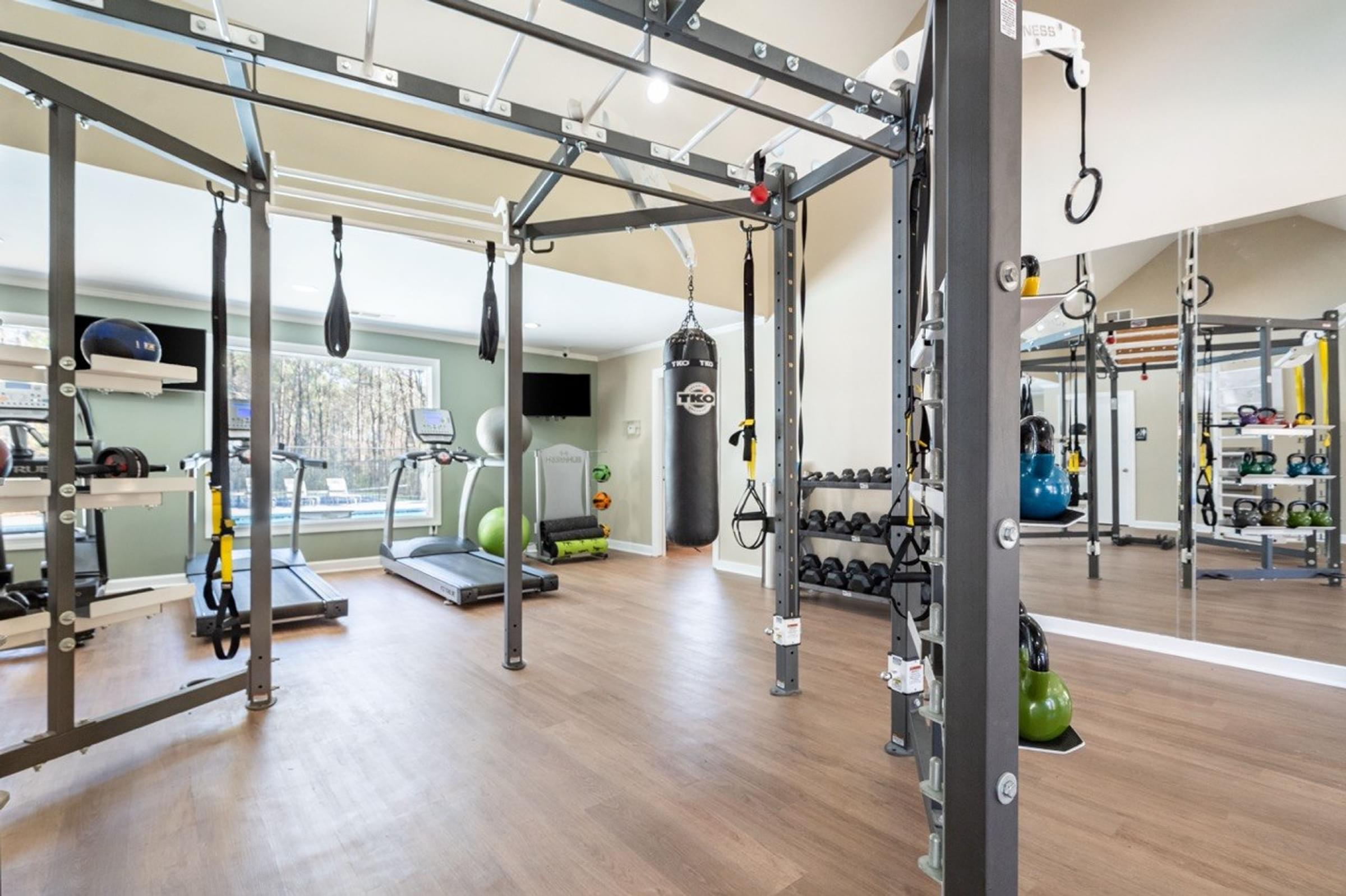 A gym with a variety of equipment including a treadmill, weights, and a bench press