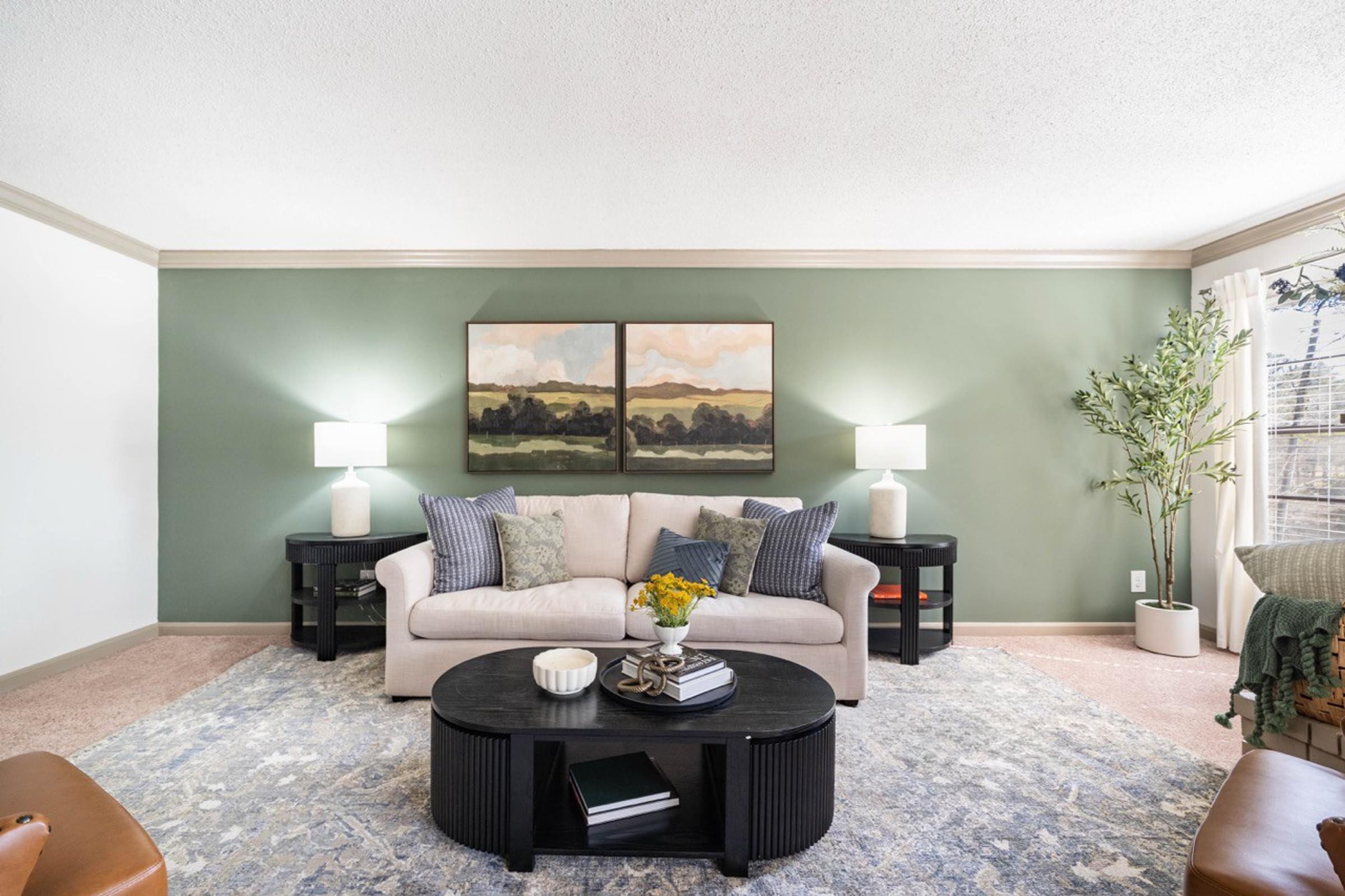 A living room with a couch, coffee table, and two lamps.