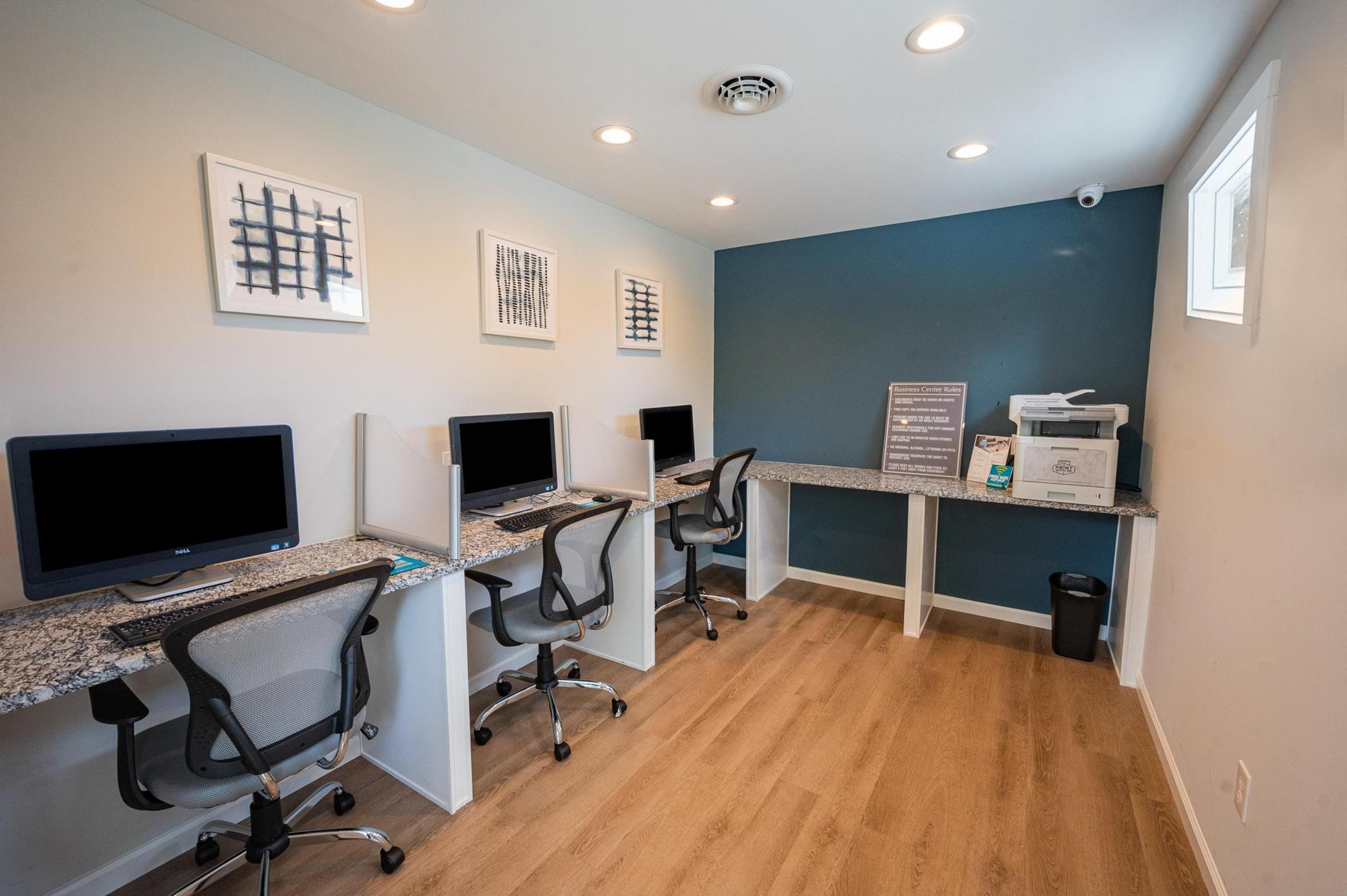 a computer room with three desks with computers and monitors