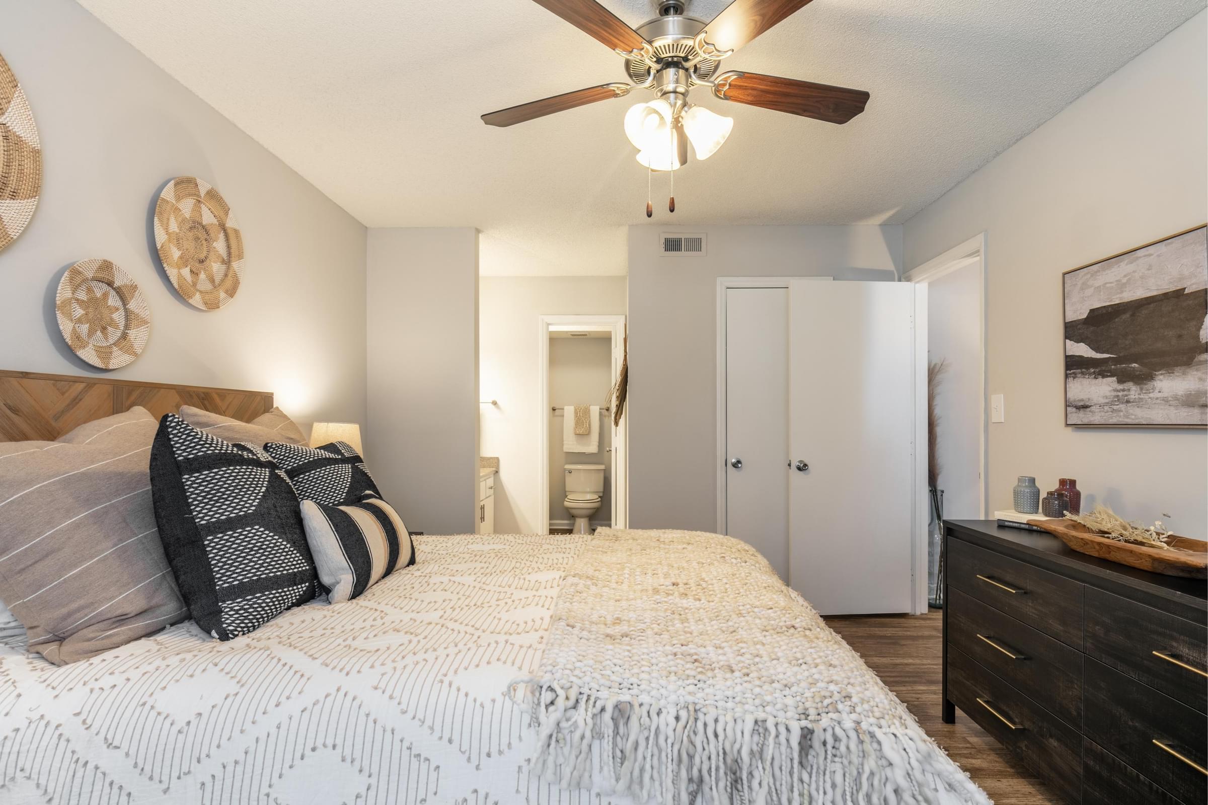 a bedroom with a large bed and a ceiling fan